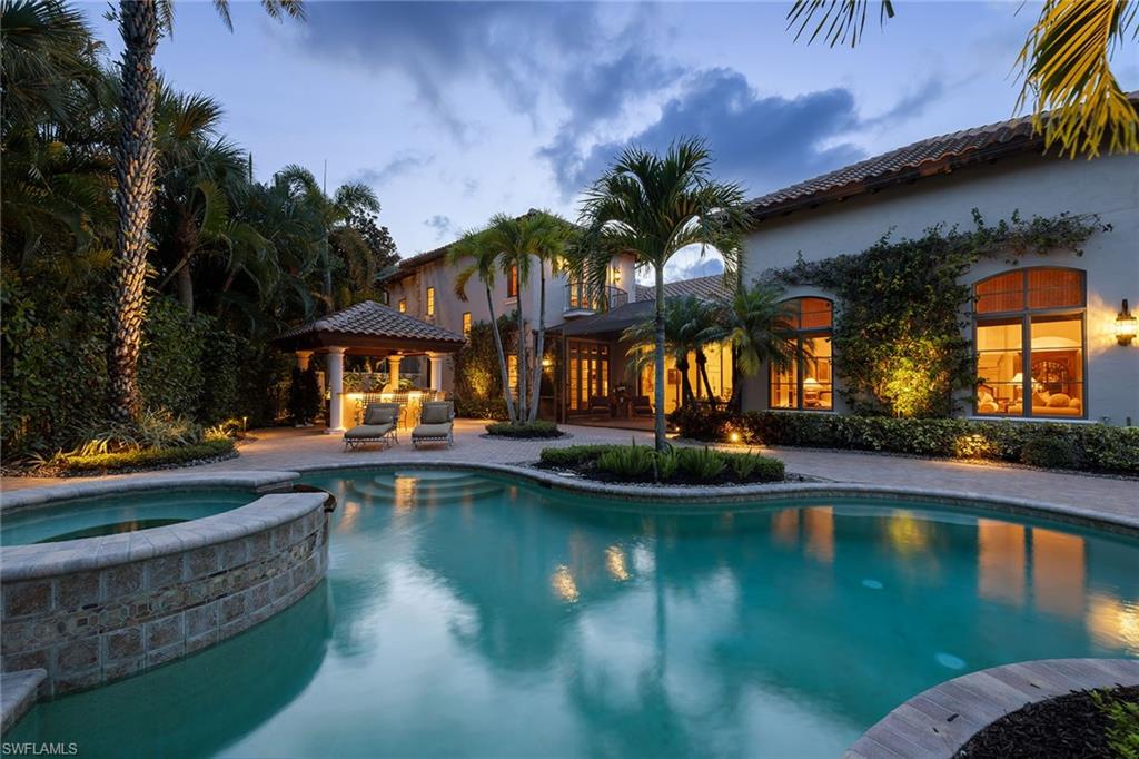 IMMEDIATE GOLF MEMBERSHIP OPPORTUNITY! Beyond a gated courtyard entry, this custom residence in Mediterra enjoys southeastern exposure with long water and golf course views. Nearly 5,000 square feet under air is defined by soaring ceilings, custom millwork, a detached casita, expansive gathering spaces and seamless indoor-outdoor living designed for everyday comfort and entertaining. The great room features cathedral ceilings with exposed wood beams, transom windows and a custom fireplace. French doors and pocketing sliding glass doors open to multiple covered and screened outdoor living areas, creating a seamless connection to the surrounding landscape. Architectural details include stained tongue-and-groove ceilings, solid wood doors, custom millwork and oversized baseboards. The kitchen blends style and function with quartz countertops and a full-height quartz backsplash, custom cabinetry, a walk-in pantry and premium appliances. Adjacent living and dining areas transition effortlessly to the outdoor living spaces. The private primary suite offers a sitting area, French doors and a custom walk-in closet. The primary bath features dual vanities, a makeup vanity, soaking tub, frameless glass shower and custom tile finishes. Guest suites are thoughtfully positioned throughout the residence, while the detached casita offers flexibility as private guest accommodations, extended family quarters or a fitness studio. Outdoors, a freeform pool and spa overlook the lake and golf course. A covered cabana with a built-in grill, beverage cooler and sink creates an inviting setting for alfresco dining. Retractable screens and integrated audio enhance year-round comfort. Additional highlights include impact-rated windows and doors, Lutron lighting, custom closet systems, integrated speakers and a climate-controlled garage with epoxy flooring and a vehicle lift. Recent improvements include a new roof completed in 2024 as well as a whole-house Generac generator. Members of The Club at Mediterra enjoy two Tom Fazio-designed championship golf courses, tennis, pickleball, fitness amenities, dining venues and an active social calendar. Membership also includes access to Mediterra's private Gulf-front Beach Club with direct beach access, indoor and outdoor dining and Gulf of Mexico sunset views. A new Sports & Lifestyle Center is under construction and anticipated for completion in 2027. Ideally located near Mercato, Waterside Shops, Gulf beaches, dining and cultural attractions, this residence offers an exceptional opportunity to enjoy the Mediterra lifestyle.