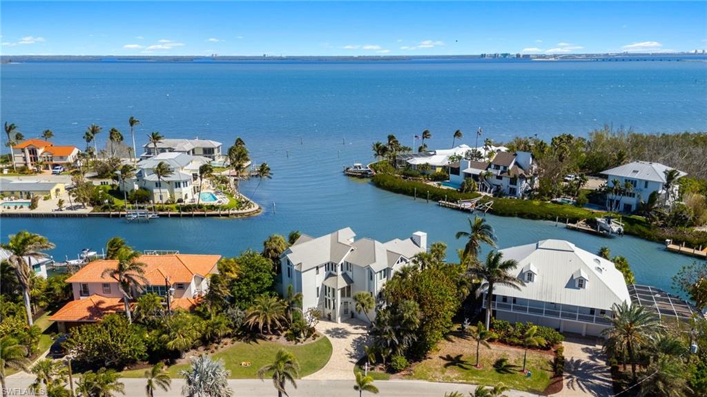 A rare Sanibel waterfront sanctuary, where luxury meets the open bay. Tucked away at the meeting point of two saltwater canals and the vast expanse of San Carlos Bay, this reimagined Sanibel retreat is a masterclass in waterfront living. With only a handful of homesites on the island offering this level of exclusivity, the owners saw an opportunity to create a residence worthy of its desired location, investing nearly $1 million in high-end renovations to elevate every detail. Here, the water is more than a backdrop, it’s a way of life. Wraparound bay and canal views immerse you in the scenery, where dolphins play, snook glide beneath the surface and the rhythmic tide draws manatees inshore. Designed for the yachting enthusiast, this prime location boasts some of the deepest boating access on Sanibel. A newly fortified shoreline features a 100-foot seawall, a 60-foot composite dock and a 28,000-pound boat lift, ensuring effortless passage to open waters. Go inside, and every space is an invitation to indulge. The main living areas were reimagined to maximize the sweeping vistas, while the chef’s kitchen, crafted by a luxury design specialist, seamlessly blends function with artistry. A Thermador cooktop with a pot filler, GE Profile wall microwave and oven, Fisher & Paykel dishwasher drawers and an LG French door refrigerator with a display view window create a culinary experience that is intuitive and indulgent. Cambria quartz countertops, LED toe-kick lighting and custom tile selections add a refined touch. Post-Hurricane Ian enhancements ensure resilience without sacrificing beauty. A new standing seam metal roof (2023), four all-new air-conditioning units raised to 12 feet, resurfaced pool and spa with natural stone pavers, and an upgraded irrigation system reinforce the home’s durability. Wide-plank oak flooring, interior stair tread lighting, and Sonos-integrated sound enhance the experience inside, while cable stair railings preserve uninterrupted views of the bay. Framed for an elevator shaft, the home is primed for future adaptability. Sanibel’s rarest waterfront opportunities are counted on one hand, and this is one of them. A home where modern luxury meets the raw beauty of the bay, offering an effortless blend of elegance, privacy and premier yachting access. For those who seek the extraordinary, this is an invitation to experience it.