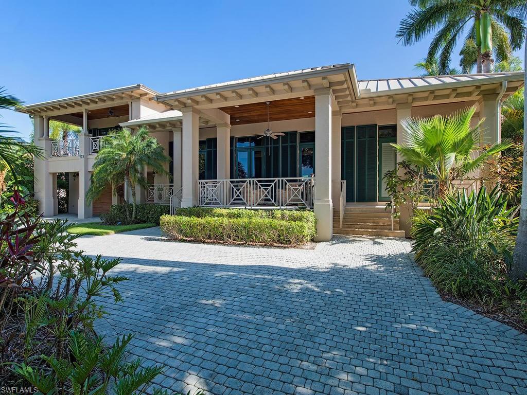 BOATERS DREAM!  Seconds to Naples Bay and only minutes to the Gulf of Mexico.  Beautifully crafted residence with scenic front and rear water views in an unsurpassed location in Aqualane Shores.  This distinctive Florida style home is nestled amidst lush tropical foliage with a brick paved circular driveway.  Ideal for entertaining, this gracious 3,514 square foot residence boasts of the finest in architectural elements including 200 mph impact windows and doors, vaulted cypress ceilings, fantastic gourmet kitchen with large island, double oven and wine cooler.  Other fine attributes of the property feature extensive covered decking, remodeled covered boat slip, swimming pool, gas grill conveniently located next to the pool, and a four-car garage.
