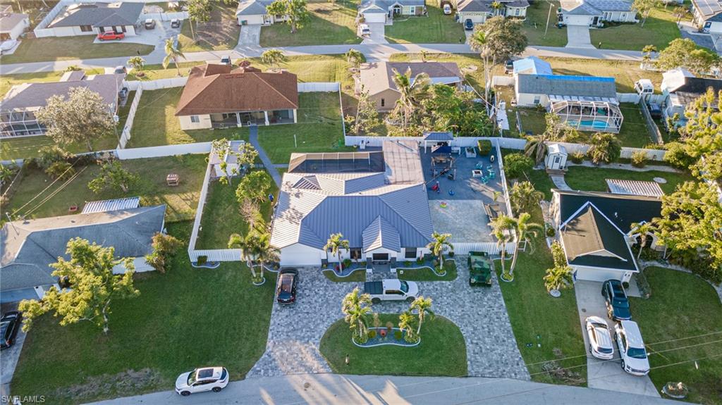 TRULY A UNIQUE GEM!! This property is an owner's pride, it has a metal roof with foam insulation, impact windows, custom cabinets with stainless steel appliances, tile throughout. Custom cabinets in garage, with wine cooler and cigar humidor, tankless water heater and Wi-Fi garage opener. It comes ready with the outlets to connect a generator, and RV. Saltwater pool, security system, surround system throughout and lanai area. Outside it has a bar, hibachi, gas stove, fridge, ice maker and many extras. You have to see this house to appreciate it. The outside shed is big enough to make it into a mother-in-law. Make an appoint today!! This is not your standard home...
