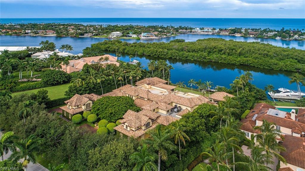 H.16258 - Magnificent home and guest house on a gorgeous double lot in Port Royal with forever, wide-water views of Old Harbour Channel, the protected mangrove preserve and glorious sunsets! Enjoy exceptional privacy from this oversized homesite with over 1.23 acres of prime waterfront in a prized location. Totaling over 14,000 sq. ft. of A/C living area. Property is comprised of the Main home, a 2BR/2BA/Living room Guest House, plus separate Staff Quarters. Enjoy the extensive outdoor entertaining areas, pool, spa, cabana, courtyards and terraces and of course the yacht basin dockage with easy, direct Gulf access. Inside there is a gym with full bath, private master sitting room, library, game room, theater room, study, walk-in pantry, butler's pantry, staff break room, a work shop and four garage spaces. Too many upgrades and luxury features to list here. Port Royal Club membership eligibility.