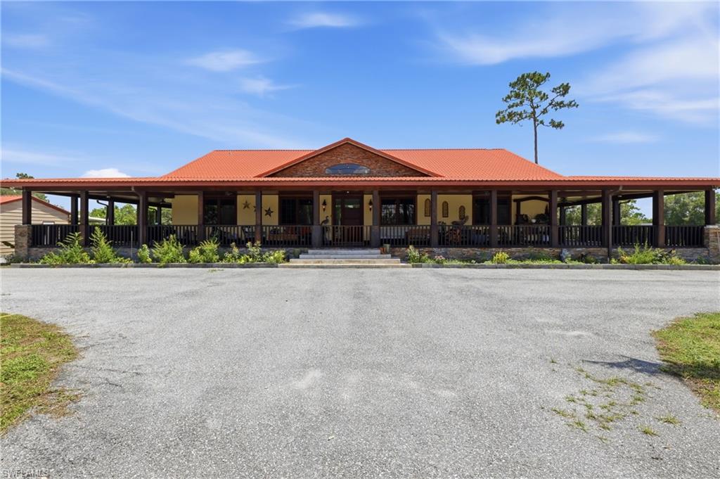 Potential to own up to 7.50 acres! This exceptionally rare luxury ranch is situated on 5 fully fenced acres on a desirable corner lot at the end of a peaceful dead-end road, offering unmatched privacy with no traffic. Featuring 3,536 total sq ft, this stunning home includes 4 rooms and 5 bathrooms, including 2 convenient exterior bathrooms with showers right by the tiki barbecue. Inside, you’ll find cathedral ceilings, top-of-the-line kitchen appliances, a breathtaking waterfall island, barn doors, spacious living areas, a laundry room, and a luxurious primary suite with his-and-hers walk-in closets. Designed for enjoying the Florida lifestyle, the home boasts an incredible wraparound porch with ceiling fans throughout, a tiki hut with BBQ area, a shed, a pond, and plenty of room to add a resort-style pool. Animal lovers will appreciate the horse-friendly setting, chicken coop, fully fenced acreage, and expansive open space. Additional features include a gated entrance, long driveway leading directly to the home, security cameras, aluminum carport, steel-frame storage building/shed, and endless room for recreational vehicles, equipment, or future expansion. Two adjoining parcels may also be available for purchase, creating the rare opportunity to own approximately 7.50 acres total. This one-of-a-kind property offers the perfect blend of luxury, privacy, acreage—all while providing the peaceful country lifestyle you’ve been dreaming of.