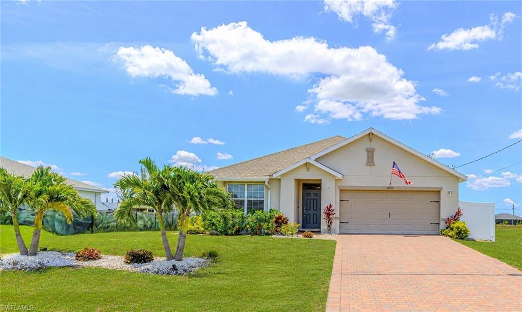 Move-in Ready, Meticulously maintained, Solar-equipped 2023 built • Quantum Fiber pre-installed • Not in a flood zone. This 3-bedroom, 2-bath single-story home offers 1,671 sq. ft. in NW Cape Coral, with no HOA, a 2-car attached garage, and a split-bedroom layout centered on open living, dining, and kitchen areas. The white kitchen features 36-inch designer cabinets, quartz countertops, pendant lighting, breakfast bar seating, a center island, a walk-in pantry, stainless steel appliances, and an included washer and dryer. Tile flooring runs through the main living areas and baths, with carpet in the bedrooms. Interior features include vaulted ceilings, a walk-in closet, dual sinks in the primary bath, pull-down attic stairs, and window coverings. Outdoor living includes a screened, paver lanai, a brick paver driveway, a full irrigation system, and room for a future pool. Practical upgrades include a whole-house surge protector and a portable generator plug installed. NW Cape Coral location near Coral Oaks Golf Course, Burnt Store Boat Ramp, and the planned Seven Islands.