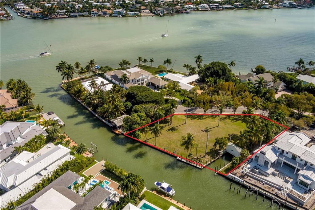 One of a kind Aqualane Shores estate lot featuring 181 ft of waterfront and 238 ft of street frontage lined with beautiful mahogany trees. This property measures approximately 27,400 sq. ft.(.63 acres) and is virtually twice the size of a standard Aqualane Shores lot. Here is an opportunity to build your new custom estate home with lots of green space, multiple garages, and extensive dockage for your fleet of boats. Comes with a  60 ft. cut-in boat slip than can be covered with a roof to protect your yacht.  This is a car collectors dream! Lot size allows for a motor court and multiple garages to accommodate as many as 8-10 cars with the use of lifts.  There is plenty of space to build a separate pool cabana / guest quarters either poolside or above your detached garage. This spectacular building site sits one house away from Naples Bay providing views of the bay from your dock and second story of your new home. Towering royals, coconut palms, gumbo limbos and mango trees add to the uniqueness of this amazing estate sized property. The lot is located at the very end of 18th Ave South in a private setting, walking distance to the beach and 3rd street shopping and dining. This is the last of its kind in Aqualane Shores.