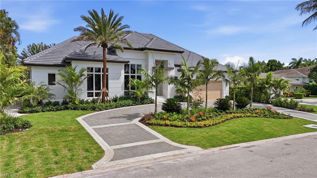 Experience refined coastal living in this exceptional new construction residence in Park Shore, masterfully built by Borelli Construction with interiors and furnishings curated by Clive Daniel Home. Designed as the ultimate private retreat, this home seamlessly balances grand-scale entertaining with thoughtful everyday functionality. The front entry is inviting with tabby shell stucco, an iron and glass front door and an arch detail in the foyer that sets the tone for the home. The expansive open-concept layout is anchored by a chef’s kitchen outfitted with Sub-Zero, Wolf, and Cove appliances, a custom tiled range hood, and a charming window bench. A sophisticated bar—complete with a Sub-Zero wine cooler, beverage refrigerator, and custom glass and chrome shelving—enhances the home’s entertaining appeal. A fully-equipped butler's pantry leads you to the cabana through a breezeway. The sunny great room showcases elegant rounded built-in cabinetry with integrated storage, a Samsung Frame TV, and fully pocketing sliders while the formal dining room makes a striking impression with its iron and glass archway, opening via bi-fold doors to the outdoor living spaces and accented by a stainless steel inlay in the wood flooring. The main residence offers four bedrooms and four full baths, including a luxurious primary suite designed for relaxation. The spa-inspired bath features a wet room with soaking tub and shower, dual vanities, two water closets and stealth speakers. Dual oversized closets provide exceptional storage, enhanced by third-level electric pull-downs. The primary bedroom also includes a private sitting area with direct access to the fire pit. A detached cabana serves as a fully functional office with tranquil pool views and its own pool bath—ideal for working remotely without compromising privacy. Outdoor living is elevated with an oversized lanai equipped with electric screens and shutters, plus a door for convenient pool access. The pool stretches beyond 50 feet for ultimate enjoyment. The backyard is finished with low-maintenance artificial turf and benefits from desirable southern exposure. Additional highlights include a Control4 smart home system with speakers & security cameras, Lutron lighting automation, hardwired window shades, and European white oak flooring throughout. Perfectly positioned, this home offers close proximity to everyday conveniences and premier destinations including Starbucks, The Fresh Market, Publix, as well as upscale shopping and dining at Waterside Shops, The Village Shops on Venetian Bay, and Fifth Avenue South. Residents also have the option to join the Park Shore Association for private beach access for a nominal fee. Finding luxury new construction in Naples has never been easier.