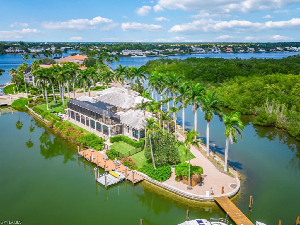 A Rare Find with over 600+ feet of waterfront and quick direct access out Gordon Pass to the Gulf. Your private 65’ dock with 15,000 lb lift, and plenty of room to expand, sits just outside your expansive outdoor living area with pool and barbeque kitchen. Inside, this 5400+ sq ft home has 4 bedrooms, 5 full and 1 half bath, plus a “crows nest” den overlooking the marina. Two of the bedrooms, with two baths and a sitting room with kitchenette occupy a secluded second floor wing which adds to its privacy and quiet. All of this in the gated community of Windstar, a unique club which gives you both a deepwater harbor as well as a Tom Fazio designed golf course just minutes to Olde Naples famous 5th Avenue and Beaches. Other Club amenities include a dining room overlooking Naples Bay, tennis and fitness programs, as well as other social activities. Windstar also offers a shuttle boat to Keewaydin Island with its unspoiled beach. Just outside the gates you’ll also find Bayshore Drive with its unique array of restaurants and watering spots. Plenty to do within reach or just relax and enjoy this beautiful one-of-a-kind home.