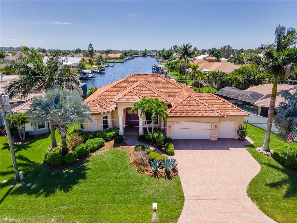 Waterfront Dream Home with a beautiful Southern Exposure! Located in one of the most desirable areas in Cape Coral. Home features a large 3 bedroom with a Den, 3 car garage, 2,476 SqFt under air, and volume ceilings. Enjoy the large clear view screened outdoor space with an amazing infinity pool and spa, outdoor shower and plenty of room for entertaining. Spacious master suite with private entrance to the outdoor space overlooking the infinity pool and canal, 2 large walk-in closets, heat lamps outside of the shower for your comfort and dual sinks. Home has a 9.2 foot elevation, Sea Wall, and room for a boat dock. You will instantly fall in love with the charm and warmth of this home.