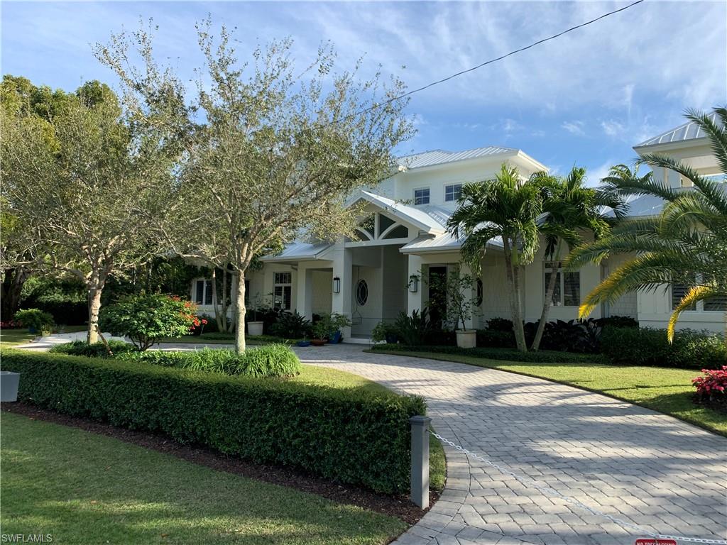 This Old Naples home is freshly and beautifully furnished by Clive Daniel Home.
Positioned on one of the largest interior parcels in Old Naples, at nearly half an acre on southern exposure, this residence ensures total privacy and abundance of space, inside and out. A custom residence with focus on the outdoor areas, the lap lane pool features an oversized shallow shelf. The covered outdoor living has motorized screens and fireplace, and the adjacent outdoor dining area features a custom sail shade system to provide shade from the southern sun, just off the pool deck. On the eastern side of the property, a rare, generous side yard made in KoolMax synthetic turf truly shows the immense size of the lot. Inside, the 1st floor master suite has french door access to the pool. There is a den and media room also on the 1st level. Upstairs, three en suite bedrooms and a loft ensure ideal guest accommodation. A rare attached guest house with kitchenette, dining area, and en suite bedroom has its own exterior private access. A truly unique offering just a few blocks from the Gulf of Mexico and the fine shopping and dining of 5th Ave South.
