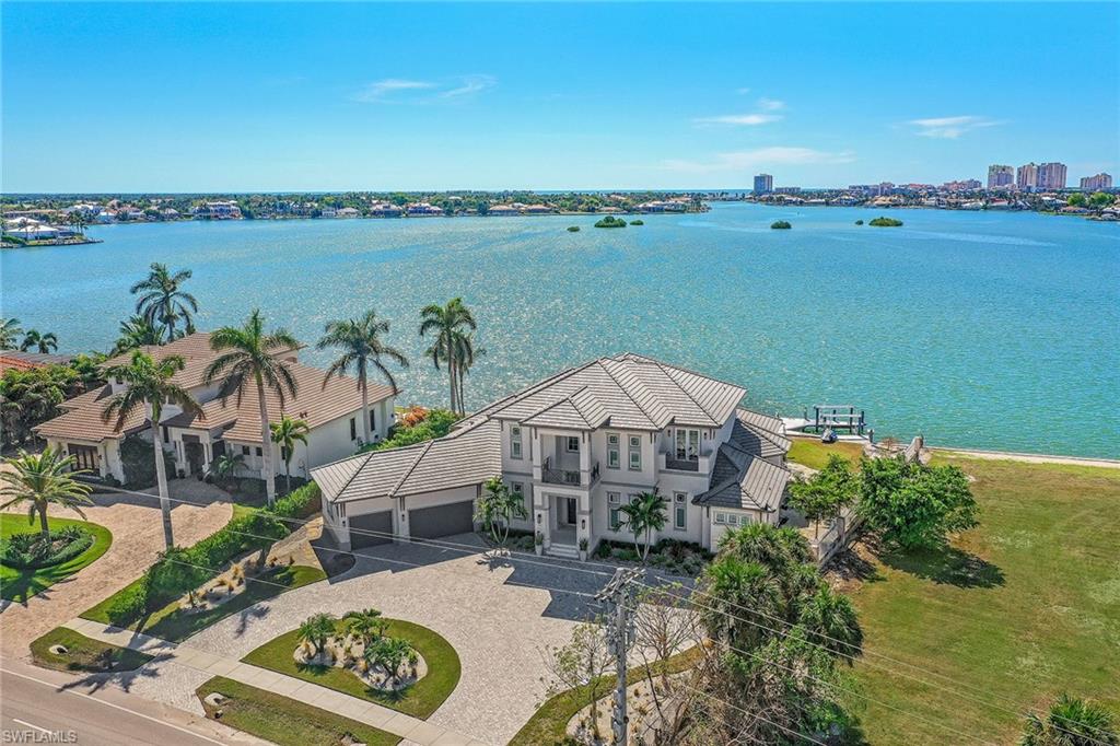 Gorgeous panoramic views of Roberts Bay and beyond greet you as you enter into this stunning coastal contemporary custom-built 6-bedroom plus den, 6-and-a-half-bath home located in the pristine Estates area of Marco Island. Perfect SW exposure to enjoy the beautiful sunsets. A boater’s paradise with dock and two lifts providing quick easy access to the Gulf of Mexico. Light and bright open great room with spectacular glassed bar area blends harmoniously into a gourmet chef’s dream kitchen with custom cabinetry, stainless appliances with built-in wall oven and cooktop, large butler’s pantry, island with breakfast bar and separate eating area all open to enjoy the serene bay views. The downstairs master en-suite retreat has it all with soaking tub, shower, double vanities and spacious custom walk-in closets. The 2nd floor has a relaxing family room, wet bar and private open lanai. The additional 5 bedrooms and baths are perfect for your guests. An open sweeping veranda with infinity pool, spa, and outdoor kitchen is the perfect place to soak in the mesmerizing views. 3-car garage, generator, elevator, circular drive, impact glass, electric shutters & screens. Your dream home awaits!