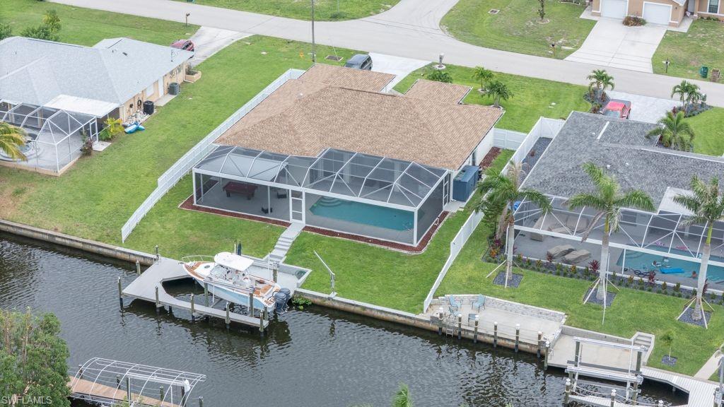 A home with direct access to the Gulf—with no bridges in the way! Set sail from your own backyard on your sailboat or yacht straight into open waters. Features include a brand-new 12,000-pound boat lift and a dock installed in 2025. Available now! This home has been completely remodeled (2025) with luxury finishes throughout—from the new kitchen, bathrooms, and tile flooring, to the woodwork and fresh interior and exterior paint. Watch the beautiful sunset over the wide canal—which offers direct Gulf access—from your pool area, the screened-in pergola (2025), or the waterfront dock. Enjoy the fully equipped outdoor barbecue area. This home boasts an excellent floor plan, featuring a kitchen that flows seamlessly into the family room, large windows fitted with new "zebra-style" blinds, and 8-foot-tall sliding glass doors that flood the living space with natural light and offer marvelous views. The property features lush landscaping and offers 3 bedrooms and 2 bathrooms. It enjoys close proximity to the entertainment district of downtown Ft. Myers (10 minutes away) and shopping areas in Cape Coral, such as the Walmart Supercenter (5 minutes away). The roof was installed in 2020, and the air conditioning unit in 2024. Don't just take our word for it regarding this Cape Coral gem; schedule your appointment to see it for yourself while it is still available!