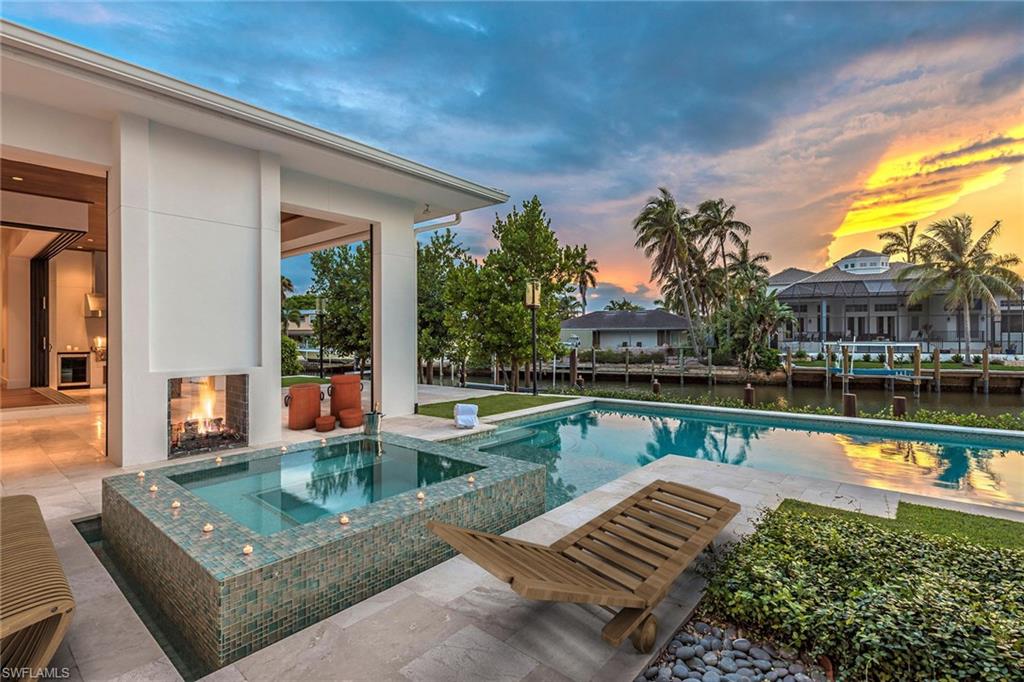 WELCOME TO A MODERN MASTERPIECE! IT IS THE HOUSE THAT HAS EVERYTHING! Enjoy the ultimate lifestyle of boating, fishing, swimming, relaxing, entertaining, all in this magnificent home located just minutes to our world famous beaches and downtown Naples. This exceptional contemporary waterfront home is cool, calm, sophisticated and enveloped in light and comfort. Waterfront luxury living awaits you with the highest quality finishes throughout and the most desirable sought after cul-de-sac in Royal Harbor. Enjoy Miele appliances in the gourmet chefs dream kitchen including a built-in espresso station, custom Italian cabinetry, Du Chateau walnut wood floors, 500+ bottle wine room, 2-fireplaces, dream master suite, spa-like master bath, guest suite offers sitting room with private balcony, two additional bedrooms en-suite are adjoined by a loft complete with its own mini bar and fridge, cutting edge technology, closets galore, enviable huge outdoor living space with 100 ft seawall, deep saltwater heated pool with infinity edge spa, Ipe dock with 2 lifts, outdoor kitchen with Lynx gas grill, complete with even an air-conditioned fish room. For the most discerning buyer!