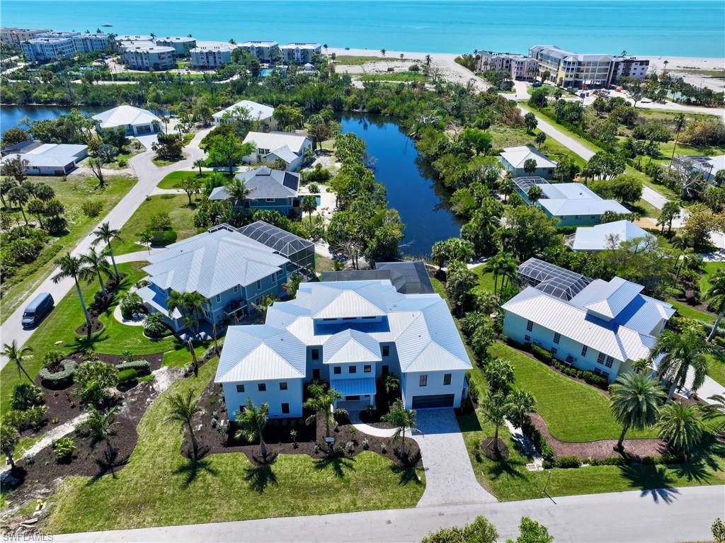 New Construction on Sanibel Island - professional photos coming. Step into coastal luxury with this exceptional estate offering deeded beach access and over 11,000 square feet of total space (4400 under air). Built with solid concrete and ICF (Insulated Concrete Form) construction, this home delivers superior storm resistance, energy efficiency, and peace of mind—without compromising elegance. Designed for both refined living and effortless entertaining, every detail reflects timeless craftsmanship and modern sophistication. At the heart of the home is a designer chef’s kitchen outfitted with premium Wolf and Sub-Zero appliances, complemented by a built-in Miele coffee station, 60" dual fuel Wolf range, Wolf steam convection oven and speed oven, 36" Sub-Zero refrigerator and 36" freezer and 30" wine cooler. Custom Wood-Mode inset cabinetry pairs beautifully with Cambria and Pompeii Quartz countertops, creating a space that is as functional as it is stunning. Retreat to the expansive primary suite, where long lake views provide a serene coastal backdrop. The spa-inspired bath elevates relaxation with a luxurious wet room, soaking tub, and private steam room with shower—your personal sanctuary after a day at the beach. Indoor living flows seamlessly to your private outdoor oasis, featuring a heated sparkling pool with sun shelf, spa, and a fully screened patio and pool enclosure—perfect for year-round enjoyment. This home is finished to the highest standards, including engineered hardwood floors, level-five drywall finish, 8-foot solid core doors, crown molding throughout, and thoughtfully designed built-in closets. Kohler and Hansgrohe fixtures, along with LED lighting throughout, enhance both style and efficiency. Additional highlights include a spectacular shell stone travertine entry, huge primary closet, four spacious garage bays and 4.5 beautifully appointed bathrooms, ensuring comfort and convenience for family and guests alike, with tankless gas water heaters and 1000 gallon LP tank. A rare opportunity to own a meticulously crafted coastal residence where luxury, durability, and beachside living come together effortlessly.