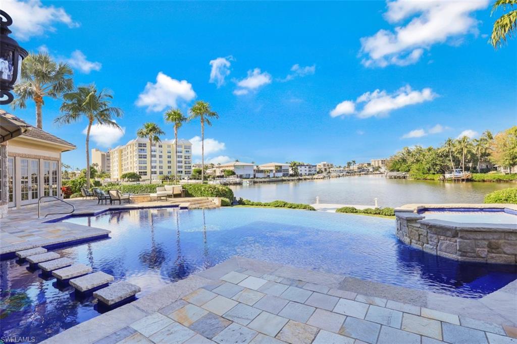 This Exceptional Moorings Masterpiece offers wide water views of Hurricane Harbor, more than 185' of seawall and new double boat dock with separate lounge platform for the epitome of waterfront living. The moment you see the limestone & grassed drive, this home gives you an Exquisite European feel. Upon entering the 9' double front doors you immediately see the attention to detail & quality. Upscale features include custom glass tiled infinity pool w/coral reef scene and integrated limestone lanai, new outdoor kitchen, motorized window treatments, phantom power screens, Home Audio Surround System, intricate volume ceilings, newly renovated Kitchen/Family Room & Master Bath w/ Wood-mode Cabinetry. The climate controlled garage w/limestone tiled floor accommodates 5 cars. The home also has an amazing gourmet kitchen featuring Viking gas stove, side by side built in Sub-Zero Refrig/Freezer & additional Built-In Refrigerated Drawers. Beautiful Rocky Mountain Hardware gives yet another added touch of class throughout. There is also a 30 KV generator and Walk-In "Safe" Safe Room in the Gentleman's Closet in the Master BR. This Elegant European inspired property is truly a "Must See!"