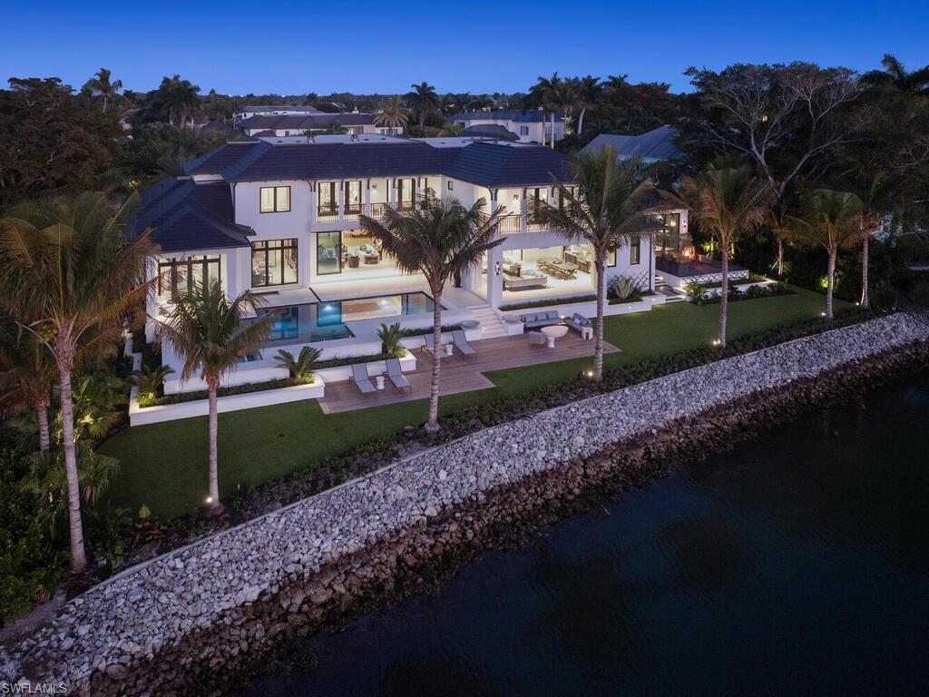 London Bay has unveiled an exceptional custom estate in Port Royal that features an impressive 160 feet of waterfront along Hidden Bay. This property boasts a desirable western exposure, providing direct access to the Gulf. The residence has been meticulously designed for both entertaining and everyday living. The architectural elements, crafted by Stofft Cooney Architects, are elegantly complemented by interiors curated by Romanza Interior Design. The estate includes expansive outdoor spaces and waterfront destinations, all surrounded by lush tropical landscaping designed by Exteriors by Koby Kirwin. The seamless integration of indoor and outdoor areas is further enhanced by resort-style amenities and private guest accommodations. On the main floor, you'll find a spacious primary retreat with custom closets and dedicated laundry facilities, a study, a formal dining room, and a distinguished club room with private deck access that features a fire pit. The second floor comprises five spacious guest suites, each with direct access to a balcony, as well as a lounge and a space suitable for a personal gym. Additional features include an elevator, a generator, three laundry rooms, and air-conditioned four-car garage. This incredible property is just a short distance from the Port Royal Club and the shops and dining options on Third Street and Fifth Avenue South.