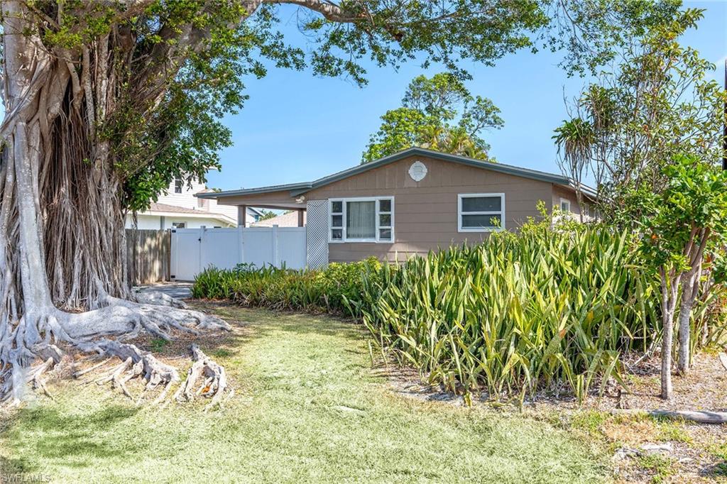 Known as "The Tree House," this charming coastal cottage retreat offers a rare blend of privacy, character and location in the heart of Naples Park. Nestled among mature tropical foliage on the sought-after 500 block west of U.S. 41, the home captures the essence of relaxed beachside living, just minutes from the white-sand shores of Vanderbilt Beach and Delnor-Wiggins Pass State Park. Filled with natural light, the turnkey-furnished residence features two bedrooms and one bath within a thoughtfully designed floor plan. The bright white kitchen showcases updated finishes, while the coastal-inspired interiors create an inviting atmosphere that feels timeless and effortlessly comfortable. Outdoor living is at the heart of the experience, with an expansive, fully fenced backyard, a generous wood deck and multiple gathering spaces that create a private tropical sanctuary. Whether enjoying morning coffee beneath the trees, entertaining friends after a day at the beach or simply unwinding in the shade, the setting offers a peaceful escape from the everyday. With no HOA fees or rental restrictions, Naples Park continues to be one of Naples desirable coastal neighborhoods. Ideally near Mercato, Whole Foods, boutique shopping, acclaimed restaurants and entertainment, this distinctive cottage retreat presents an exceptional opportunity to enjoy the Naples lifestyle just minutes from the beach. As Naples Park continues to evolve with new luxury construction, properties in this location offer exceptional long-term appeal. Here, buyers enjoy the rare combination of a charming, move-in-ready cottage and a homesite in a neighborhood where land alone often represents substantial value. Enjoy it today as a private coastal retreat, seasonal getaway or income-producing investment while benefiting from the enduring desirability and future flexibility of this sought-after beachside setting.