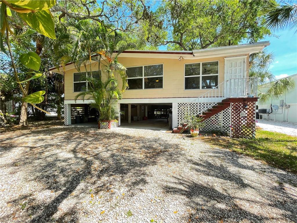 The opportunities are limitless in this quaint Fort Myers Beach home with its oversized lot nestled on a quiet street, direct beach access, 2 bedrooms, 2 full bathrooms, weekly rental income, & loads of room for a pool. Enjoy endless views of the mature Oak trees & grounds from your 2nd floor screened balcony. The entire living space is filled with natural sunlight through the impact-resistant windows. The huge under-building storage area is ideal for equipment and recreation. Additional upgrades include: private access to the balcony through the primary bedroom, electric shutter protection on rear door, newer AC, upstairs laundry, and 2nd-floor storage area. Weekly rentals!