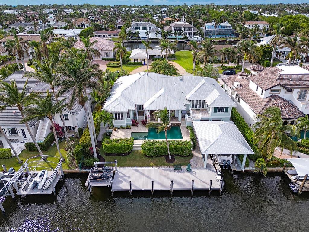 Falconer Jones designed custom built home on wide water canal. Includes a covered boat house with lift, 55’ dock with additional jet ski platform lift and covered storage for boating equipment creating the perfect boaters dream. This expansive 5 bedroom home includes first floor primary suite as well as en-suite guest bedroom.  There are 3 additional bedrooms located on second level along with a large entertainment area, morning kitchen and walk-out sundeck.  Main level includes a chef’s kitchen featuring Wolf and Subzero appliances and beautiful teak island creating a seamless transition to expansive great room.   Enjoy the Florida lifestyle with outdoor covered entertaining area, gas fire place and summer kitchen overlooking the pool and waterway.  Oversized 4 car garage with elevator access to all floors completes this Aqualane Shores residence all within close proximity of beaches and renowned Third Street dining and shopping area.