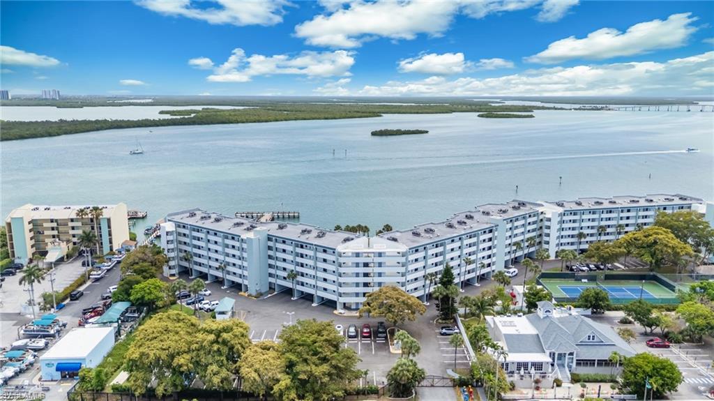 Enjoy the breathtaking wide water views of the Marco River and Jolly Bridge from this 2ND FLOOR condo located in this one-of-kind extremely popular gated community. Bringing to market this exceptional investment property at the LOWEST price in the complex at time of listing. Turnkey, furnished ,new lanai cages, impact glass windows & doors, new sliders and doors. Exceptional amenities including two pools, hot tubs, boat slips, marina,  Pelican Fishing Pier, tennis courts, pickle ball, gas grills . Maintenance fee included ELECTRIC, water & cable, internet/Wifi. Allows nightly, weekly and monthly rentals.  Superb opportunity to this tropical paradise . Tremendous Value. Perfect for personal or rental .