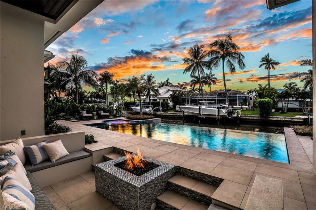 This luxurious resort style residence offers an impressive level of finishes & design. Perfect location for the boating enthusiast with its deep water canal & direct access to Naples Bay & Gulf. This new waterfront home focuses on quality craftsmanship with an array of natural stone & wood elements. This timeless beauty offers white oak wide plank flooring, smart home w/ whole house multi-room audio system, in house elevator & linear slot AC diffusers.  The exquisite main floor master suite has picturesque views & an outstanding bathroom with a free standing tub & custom shower with multiple body sprays. The second level offers a study with wet bar & balcony & three spacious en-suite bedrooms. The customized kitchen is a wow factor with Carrara 3 D tile to the ceiling, custom cabinetry, Quartz counter tops & Wolf appliances. Adjacent is a gathering room with a wine cellar & is enclosed with sliding glass doors. The magnificent outdoor living setup is complete with a saltwater infinity edge pool/spa, sunken sitting area w/gas fire pit, pool bathroom & an outdoor kitchen w/ automated screens. Dock is being installed to complete this boating paradise & can be sold without furniture..