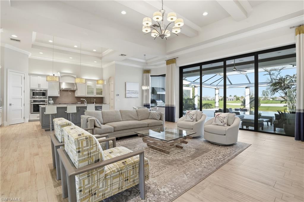 Set on nearly a third of an acre, this custom Harbourside residence offers a rare combination of newer construction, expansive lake views, and privacy within Talis Park. With desirable northwestern exposure, the home captures long water views and all-day sun across the infinity-edge pool and oversized outdoor living area, while maintaining a comfortable interior environment. Positioned near the owner’s gate for convenient access, the property stands out not only for its homesite size, but also for its more recent construction compared to much of the surrounding inventory.
The single-story layout includes three bedrooms plus a den and three and one-half baths, designed with clean architectural lines and an open great room concept. Soaring ceilings and walls of glass bring in natural light, while continuous tile flooring enhances the home’s cohesive, modern feel. The kitchen is both functional and well-scaled, featuring gas cooking, a large center island, walk-in pantry, and ample workspace for everyday living and entertaining. Impact windows and doors provide peace of mind, and the three-car garage offers substantial storage.
Outdoor living is a focal point, with an infinity-edge pool overlooking the lake, a full summer kitchen with gas grill and hot plate, and a generous deck designed to maximize sun exposure and usability throughout the day.
Located within Talis Park, residents enjoy a highly amenitized lifestyle with fitness facilities, resort-style pools, tennis, dining venues, a beach shuttle, and a robust calendar of social and wellness programming.