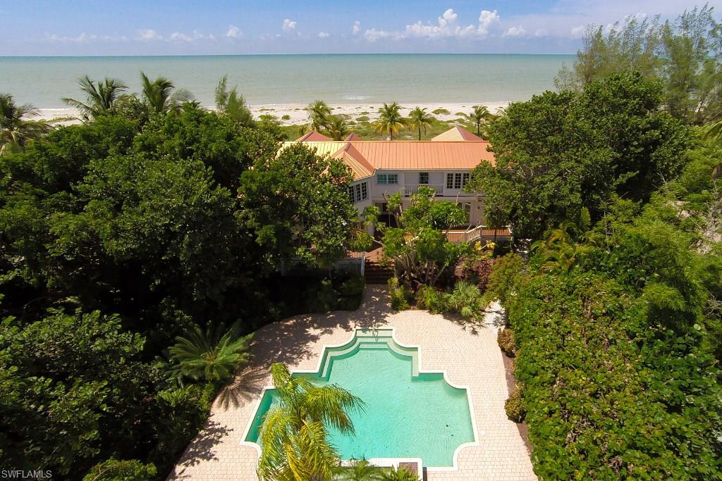-Tucked quietly away on the shores of Captiva Island sits this "timeless estate" - La Cachette. Upon entering this home, you are encompassed by the waters of the Gulf of Mexico. The living, dining, kitchen and family rooms offer panoramic views. This home meshes timeless charm with modern amenities. The kitchen boasts top of the line appliances and offers abundant cabinet and drawer space. The main house features two master suites and three guest en suites. The Master on the lower level is very romantic with a fireplace and separate sitting area. The Master on the second level features: a screened porch, separate sitting area and balcony overlooking the gorgeous gulf waters. Reminiscent of times past, this estate offers built-ins, railings, soaring ceiling and hardwood floors; you will adore the history and charm. In between the main house and guest house is the lovely pool area with cascading waterfall.  All of this is nestled quietly away on one acre of lush tranquil grounds, along the shores of captivating Captiva Island.