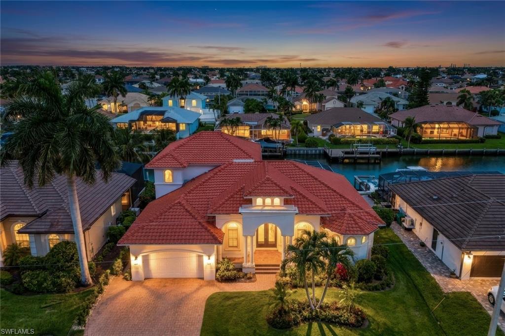 Experience the pride of ownership and attention to detail the moment you step inside this beautifully maintained waterfront residence. Freshly painted inside and out, this exceptional home offers a perfect blend of elegance, comfort, and Florida lifestyle living. The welcoming front room has been thoughtfully designed as a cozy sitting or reading room, while the spacious gathering area features stunning custom-painted coffered ceilings and direct access to the lanai, creating the perfect setting for entertaining family and friends. A bright and sunny office with plantation shutters provides an ideal work-from-home space. The gourmet kitchen is designed to impress with towering cabinetry, a large breakfast island, double ovens, cook top, glass-front cabinets, and an abundance of storage. A full wall of pantry cabinetry conveniently connects the kitchen to the laundry room. The adjacent family room is light and bright, surrounded by sliding glass doors that seamlessly connect indoor and outdoor living spaces. Throughout the home, you'll find crown molding, plantation shutters, custom blinds, updated light fixtures, and ceiling fans and designer finishes that add style and sophistication. Privately situated on the main level, the luxurious primary suite offers French doors, a tray ceiling, direct access to the lanai and pool area, a spacious walk-in closet (7x12) , dual vanities, and a stunning walk-in shower. A second guest suite on the main level features its own en suite bath, which also serves as a convenient pool bath. An additional half bath is available for guests. Upstairs, two additional bedrooms share a full bath with double vanities, while a private balcony overlooking the canal provides a peaceful retreat for enjoying morning coffee or evening sunsets. Recent updates include fresh interior and exterior paint, 8yr recently cleaned tile roof, two HVAC systems (3 yrs and 2 yrs old), and a new whole-house water purification system. The dedicated laundry room includes a utility sink, cabinetry, new appliances, and the air-conditioned three-car garage offers ample storage space. Step outside to enjoy the ultimate Southwest Florida waterfront lifestyle with a large, heated pool and new pool deck. The backyard has been enhanced with a fence, a leveled lawn area, and beautiful updated landscaping. Boating enthusiasts will appreciate the private dock, boat & jet ski lift, providing easy access to the Gulf and nearby waterways. Transferable cost flood insurance policy keeps costs down. Beautifully maintained and ideally located on the quiet end of Lamplighter, this exceptional waterfront home offers privacy and tranquility while remaining just minutes from Marco Island's world-famous beaches, shopping, dining, and entertainment.