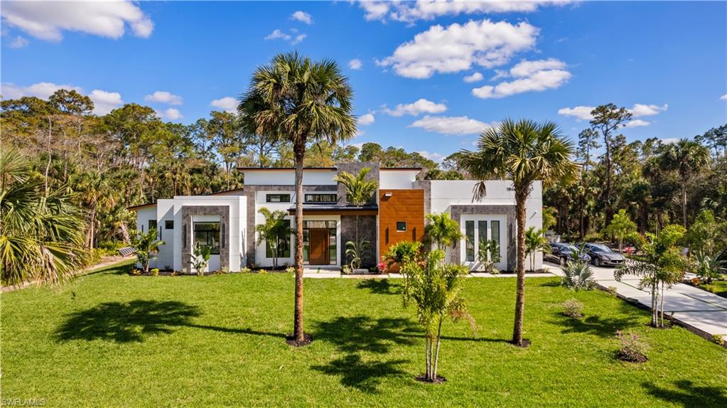 Where modern architecture is elevated by the serenity of resort-inspired living. Built by NeoLux Group, this newly completed contemporary estate showcases refined craftsmanship, timeless design, and uncompromising attention to detail. Set on 2.5 private acres, the home offers exceptional privacy while seamlessly blending grand architectural spaces with effortless indoor-outdoor living.


A dramatic 8-foot wood pivot entry door welcomes you into soaring 20-foot ceilings and expansive 10-foot impact-resistant PGT pocket sliders that fill the home with natural light while blending the interior and outdoor living spaces. Twelve-foot ceilings throughout the remainder of the home further enhance its openness, while imported porcelain tile from Spain and Poland flows throughout, complemented by oversized custom baseboards, designer Eurofase lighting, and customizable multicolor recessed lighting.


At the heart of the home, the chef's kitchen pairs Neolith porcelain countertops with custom Brazilian-crafted cabinetry and a premium Viking and Thermador appliance package, creating a space equally suited for everyday living and effortless entertaining. Complementing the main living areas, a dedicated entertainment wing features a spacious media lounge, full bar, and formal dining room.


The primary suite is a private retreat featuring a custom wood tray ceiling, expansive pocket sliders opening directly to the pool and spa, designer boutique-inspired walk-in closets, and a spa-inspired bath larger than many bedrooms. Finished with imported porcelain tile, the primary bath features a freestanding soaking tub, expansive walk-in shower, and separate makeup vanity, while every bathroom throughout the home is appointed with integrated Neolith sinks, custom vanities, luxury fixtures, and smart bidet toilets.


Outside, the resort-inspired outdoor living experience is centered on a spectacular infinity-edge pool and spa featuring a dramatic 21-foot waterfall, a 10-foot rainfall feature, multicolor lighting, dual fire pits, and a fully equipped summer kitchen with weather-resistant cabinetry, a propane grill, and a pizza oven.


Built with longevity in mind, the home is constructed on an elevated stem-wall foundation 5½ feet above street elevation and enhanced by a standing-seam metal roof, three HVAC systems, dual garage mini-split systems, dual gas-powered tankless water heaters, a 1,000-gallon propane tank, private well with a 2,000-gallon storage tank, whole-home reverse osmosis system, custom fascia and soffit detailing, and an oversized 6-inch-thick seashell-finish driveway with synthetic grass borders.


More than a residence, this is a private resort reimagined as a home.