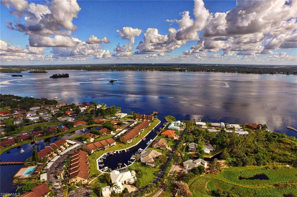 RARELY AVAILABLE! Magnificently updated - This Gulf access condo is located only steps away from its private dock and boat lift and boasts direct access to the Caloosahatchee River. This condo has been extremely well maintained and has rarely been occupied since the full remodel.  All new kitchen that has been opened to showcase the marina & sunset views. Upgraded shaker style cabinets, granite countertops, build-in wine cooler, stainless appliances, sunny breakfast nook, whole house water filtration & 18” ceramic tile throughout the home. Master bedroom has 2 walk-in closets and sliders to the lanai. The split bedroom plan provides privacy when guest arrive. The spacious den with a closet can provide for extra sleeping. Includes a private dock (a $15,000 value) and lift plus a very private personal spa. Admiralty Yacht & Racquet is an active boating and tennis community on the banks of the river. Convenient to I-75 or the activities & restaurants in the downtown, “River District”. A perfect retreat from northern winters!! Furniture negotiable.
