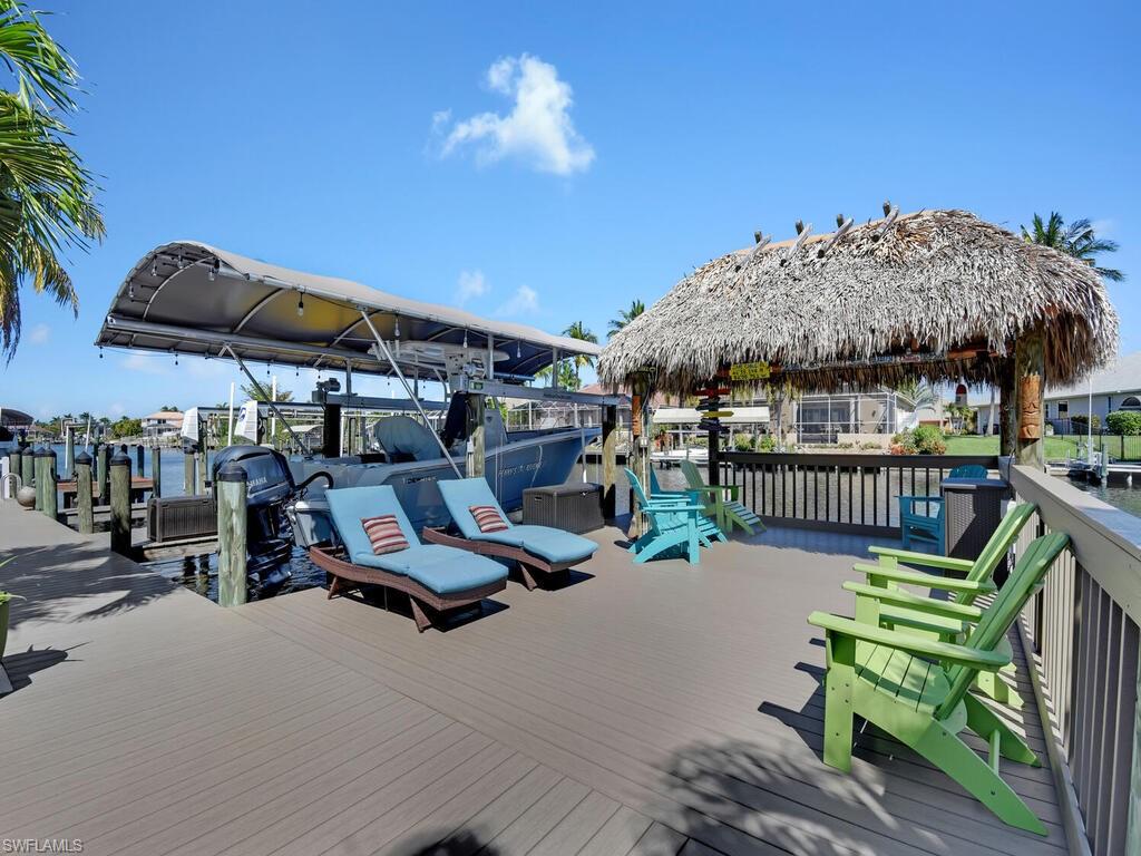 GULF ACCESS HOME! Amazing waterfront setting overlooking intersecting canals, stunning outdoor living space including pool lanai & open deck w/ tiki hut & spa, renovated gourmet designed kitchen, living & family room layout, split bedroom floor plan, formal dining room, French door & screened front entry, and 2-car garage w/ mini-slit. The extended pool lanai offers a heated pool, pavers on pool deck, large covered sitting area, and heated saltwater pool w/ remote control LED lighting system. Updated w/ new roof in 2019 with transferable warranty. new AC in 2015 w/ heat pump, renovated bathrooms, all plumbing updated to Manabloc in 2016, and the pool was resurfaced in 2017. The private boat dock not only includes a large deck w/ tiki hut, but it also has 2 boat lifts - 10k lbs & 7k lbs. Convenient location - less than 2 miles to Cape Harbour, 5 miles to Tarpon Point Marina, easy access to North Cape Coral Bridge, and just 16 miles to Fort Myers Beach.