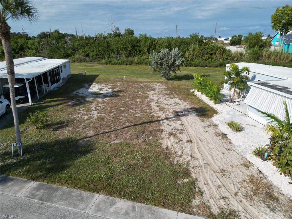 If you're not a boater or interested in a canal front lot, but want to live in an amazing, manufactured home community, then this vacant lot is for you. This lot is priced to sell quickly. The lot has been cleared and is ready for a new owner to have a new home delivered. All of this can be accomplished in a matter of months so it would be very long before you can begin enjoying all the amenities this community has to offer.  This lot has is slightly oversized which means you can fit any doublewide manufactured home and possibly even a triple wide.  Come and see this lot today and let put a deal together. Bayside Estates is the best kept secret of Fort Myers Beach. This incredibly active and friendly 55+ community is the crown jewel on the gulf coast. Bayside estates is only 2.5 miles to the beach and is accessible by either car or boat--right from either your driveway or private boat dock. A very popular activity is to ride your electric bicycles to the beach for the day and visit the world-famous Jimmy Buffett’s Margaritaville. Just don't step on a pop-top!!. Nearly all of the major retail vendors are within a very short driving distance for ultimate convenience. For those who don’t know a lot about Bayside Estates, it is a very fun place to call home---some would even say it’s a mature person’s playground. Whether you want to play pickleball, tennis or bocce ball or hang out at the community pool, or simply cruise the hood in your golf cart, there is always something going on around here. People are friendly and you will be warmly welcomed.