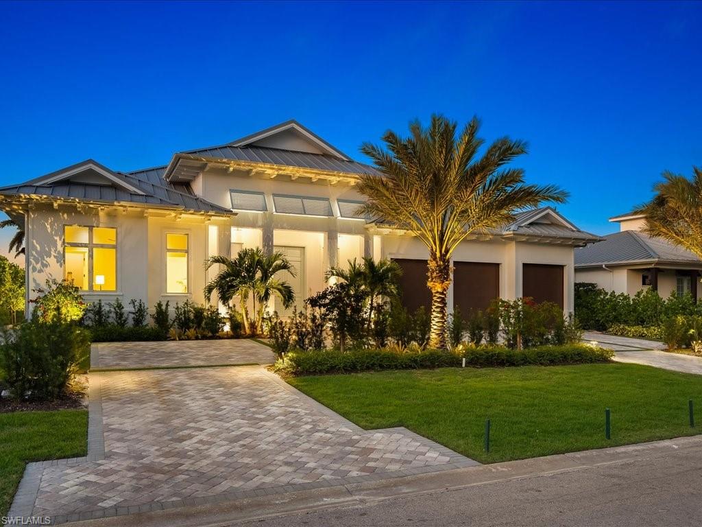 Luxury meets coastal charm. The heart of this home is a stunning soft white kitchen, accented by a French blue La Cornue range & hood. Natural white oak floors and a wooden kitchen island invite warmth & comfort into this magnificent space. Cathedral ceilings create a grand & sophisticated atmosphere throughout. Experience elegance in the circular kitchen cabinet details that flow from room to room. Entertain guests effortlessly with a stylish dining bar, complete with wine storage & ice maker. The home's interior doors feature raised circular panels & polished nickel hardware, adding an elevated touch. The lavish owners suite bath, boasting a soaking tub surrounded by Carrera marble, double sinks, & mosaic marble feature tiles adorning both the floor & the generous shower. White oak flooring in a natural finish extends throughout the residence, harmonizing with the overall coastal aesthetic. Outdoor living space, where hues of blue tile & shell stone, combined with a cedar ceiling in covered areas, create a seamless integration of indoor & outdoor living. Architecture by Falcon Design, Suzanne Costa Interiors & masterful construction by Waterside Builders.