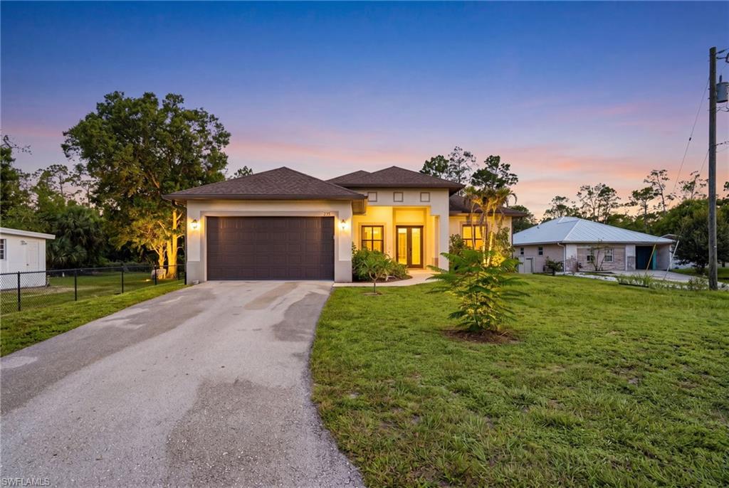 Built in 2018 and thoughtfully upgraded throughout, this move-in-ready 3-bedroom, 2-bath residence offers the perfect combination of comfort, functionality, and privacy on a beautifully cleared 1.17-acre lot with no HOA restrictions. A paved asphalt driveway with additional parking and a welcoming front porch create excellent curb appeal from the moment you arrive. Inside, the bright open-concept floor plan is designed for both comfortable everyday living and effortless entertaining. Elegant tray ceilings in the living room and owner’s suite add architectural character, while upgraded kitchen cabinetry and stainless-steel appliances provide a modern and stylish finish. Step outside to enjoy the spacious backyard featuring partial landscaping and a dedicated firepit area—perfect for relaxing evenings outdoors. The rear screened lanai extends the living space and offers an ideal setting to enjoy Florida’s year-round indoor-outdoor lifestyle. Additional features include hurricane impact windows and doors for added protection and energy efficiency, along with a whole-house water softener system for enhanced comfort and convenience and brand new HVAC system. Ideally located near shopping, dining, and everyday essentials, this property also offers easy access to some of Naples’ most desirable Gulf beaches, including Delnor-Wiggins Pass State Park and Vanderbilt Beach, both approximately 30 minutes away. Convenient access via the new Vanderbilt Beach Road provides excellent connectivity throughout Naples and surrounding areas.