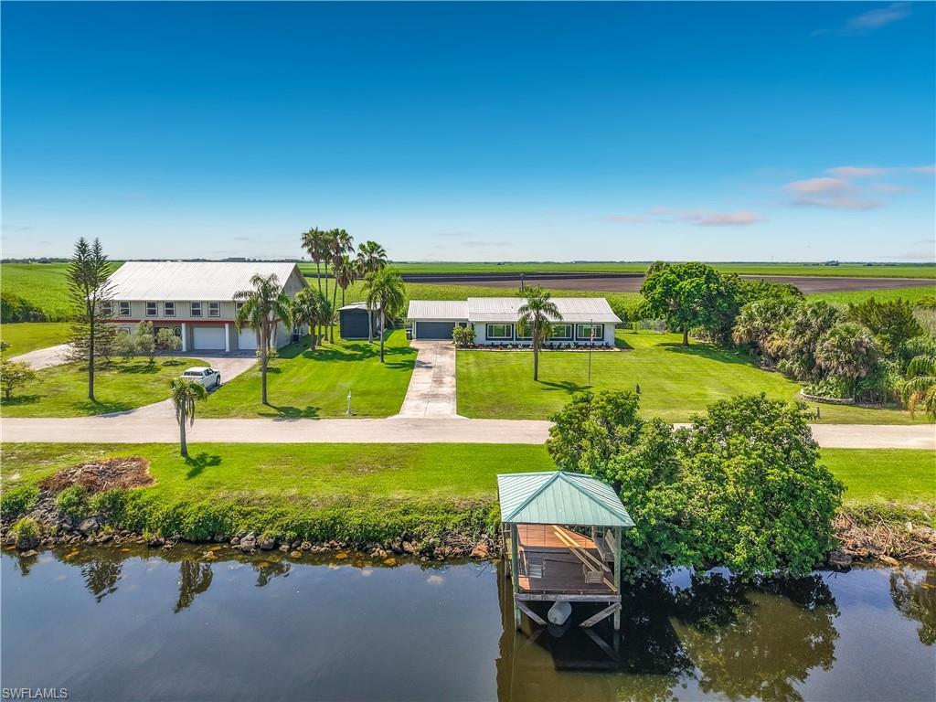 Welcome to an extraordinary waterfront property where extensive renovations, quality craftsmanship, and exceptional amenities create a truly one-of-a-kind opportunity. Originally built in 2000, this home has been extensively remodeled since 2016, with nearly every interior and exterior component updated. Beyond the original concrete block construction and foundation, virtually every aspect of the home has been enhanced for modern comfort, efficiency, and style.

Inside, the open floor plan features wood-look luxury vinyl plank flooring throughout. The foyer includes custom-built kennels for large dogs, while the spacious living room is accented by a custom faux fireplace. The remodeled kitchen offers custom soft-close cabinetry, granite countertops, under-cabinet lighting, abundant storage, and stainless steel appliances installed in December 2025. Mini-split systems in every bedroom provide individualized comfort, while the central HVAC system was replaced in 2019 and is professionally maintained.

The oversized primary suite features a custom walk-in closet, dual vanities, and a beautifully designed walk-in shower. Additional bedrooms provide flexibility for guests, hobbies, or a home office.

Major improvements include a metal roof (2017), solar panels (2018), replacement doors and windows (2019), and accordion hurricane shutters on every window. The home is served by central water and septic, while a private well supplies the irrigation system.

Outdoor living is designed for year-round enjoyment with an expansive screened lanai, an open patio featuring a custom-built fire pit, mature landscaping, and an oversized attached garage with a dedicated workshop area. Added in 2018, the 15' x 40' RV-height covered storage building features roll-up doors on both ends for convenient drive-through access and ample space for an RV, boat, trailers, or additional vehicles.

A standout feature is the deeded wooden dock and waterfront gathering area on the Caloosahatchee River. Enjoy direct boating access to Florida's Intracoastal Waterway, with routes leading west to the Gulf Coast and east through the Okeechobee Waterway and St. Lucie Canal to the Atlantic Ocean. Whether boating, fishing, kayaking, paddleboarding, or simply relaxing by the water, this property offers exceptional opportunities to enjoy Southwest Florida's outdoor lifestyle.

End each day with breathtaking sunset views across the river. Combining extensive renovations, energy-efficient upgrades, versatile living spaces, outstanding storage, and deeded waterfront access, 2795 N River Road presents a rare opportunity to own a meticulously updated home designed for both everyday living and recreation.