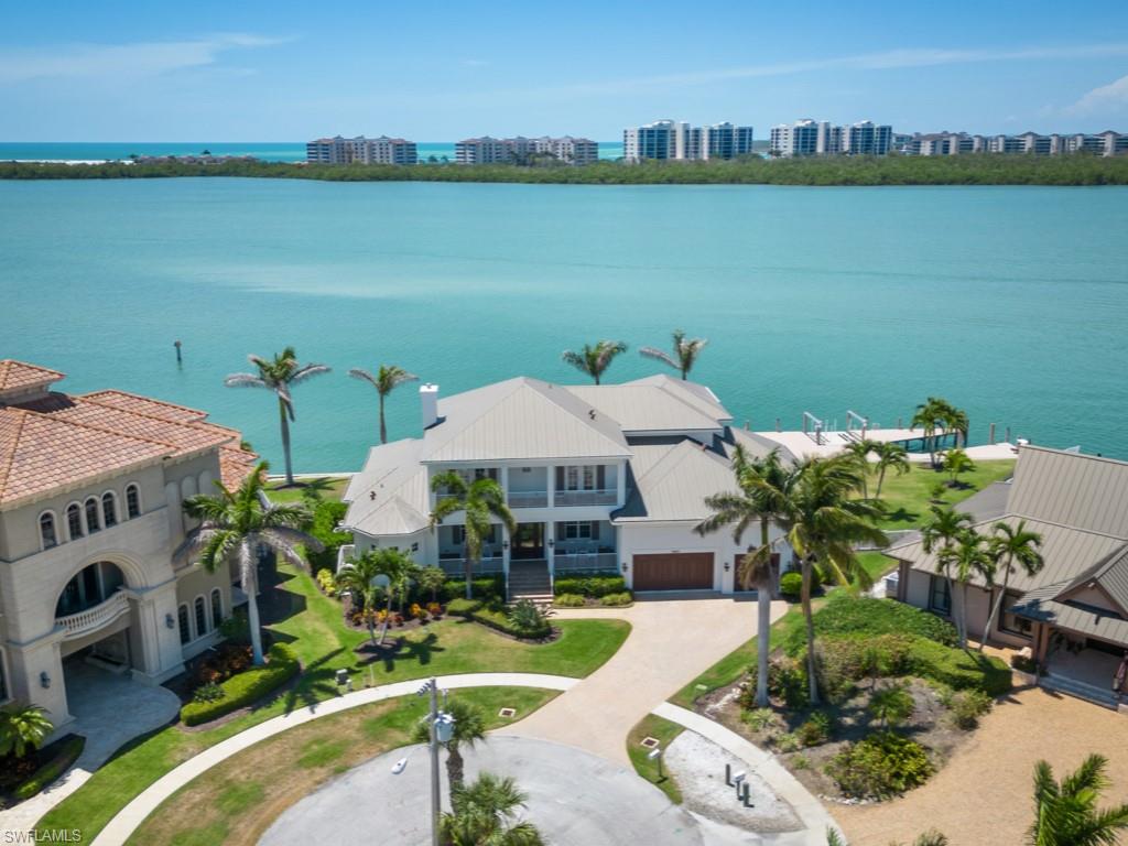 Ultimate coastal luxury living! Exceptional waterfront Marco Island residence on prestigious Collier Bay w/ unobstructed bay views. The 4BR/5BA + den home combines luxury & exquisite design elements in a coastal chic ambiance. 1st floor wainscoting, adding a touch of sophistication. Cozy living room fireplace creates a welcoming atmosphere, perfect for gatherings. True culinary kitchen is a masterpiece w/ Wolf & Subzero appliances. Bar area & butler's pantry add elegance & convenience, perfect for hosting dinner parties. Outdoors experience the essence of waterfront living: oversized pool, spa, & sun shelf to indulge in a resort-like setting, while enjoying the breathtaking bay views. Outdoor kitchen perfect for memorable gatherings while taking advantage of the tropical weather & scenery. Venture further outside to discover the boater's paradise that awaits. Huge dock offers direct access to the Gulf by boat or yacht & the tip lot has 230’ of seawall. Whether you're lounging on the dock, engaging in water activities, or simply enjoying the serene surroundings, this waterfront haven provides endless possibilities for relaxation & recreation.  Your waterfront dream lifestyle awaits!