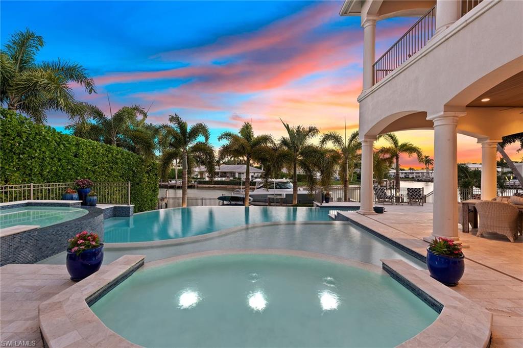 Presenting this incredible waterfront residence just steps from the private Moorings beach access and minutes from the upcoming Naples Beach Club, a Four Seasons resort. This magnificent two-story home offers four bedrooms + den, four baths, two half baths, an elevator, a three-car garage and much more. The home impresses from the moment you enter the grand living and dining room which showcases soaring ceilings, floor-to-ceiling windows with south-facing views of the bay, a gas fireplace, custom light fixtures and elegant furnishings throughout. The kitchen is sure to impress with its premium finishes, professional-grade appliances and butler’s pantry, which features its own oven and refrigerator drawers. The luxurious owner’s suite is located on the first floor, while the second floor offers three beautifully appointed guest bedrooms all with en-suite baths, a covered balcony and a large bonus room which makes a perfect home gym or upstairs family room. The home’s backyard rivals the best resorts with its open lanai and pool deck featuring an incredible infinity-edge pool/spa, outdoor kitchen and a new oversized dock area, featuring a boat lift and platform lift.
