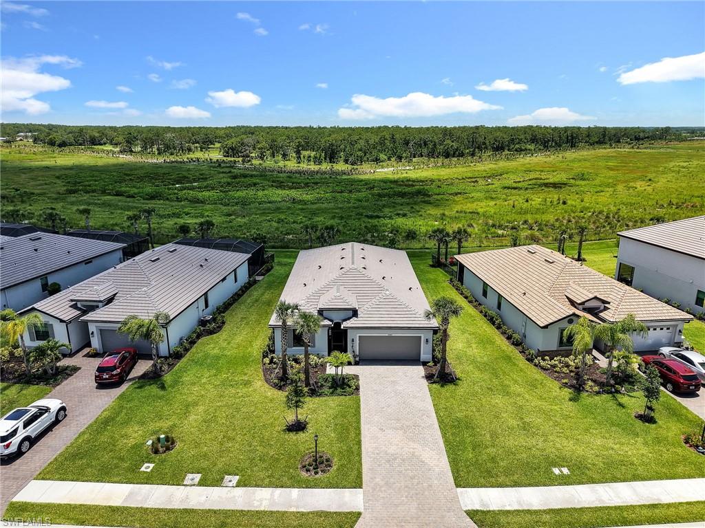 Tucked away on one of the most PRIVATE PRESERVE lots in Verdana Village, this highly sought after floorplan offers total tranquility. With no homes or distractions behind you, the setting feels peaceful, private, and relaxing from the moment you step onto the lanai. Offering 3 bedrooms plus a versatile den/flex room, 3 full baths, and a spacious open concept layout, this home blends comfort and functionality with thoughtful upgrades designed to elevate everyday living. The LARGE BACKYARD offers plenty of room for the custom pool you have been dreaming about and highly desirable SOUTHERN rear exposure, creating ideal sunshine on your future pool throughout the day. Inside, one CONTINUOUS TILE FLOOR throughout the home creates a seamless modern feel while IMPACT windows and sliders provide both storm protection and energy efficiency. The SCREENED FRONT ENTRY welcomes refreshing cross breezes without unwanted pests, enhancing the relaxed Florida lifestyle buyers crave. The AIR CONDITIONED GARAGE with mini split system adds year round comfort and flexibility for hobbies, fitness equipment, temperature controlled storage, or projects. A quick-connect GAS GENERATOR system provides convenient backup power capability during outages for additional peace of mind. The beautifully designed kitchen features extensive cabinet space, quartz countertops, and a spacious walk in pantry, delivering both style and exceptional functionality for entertaining and daily life. Additional premium upgrades include a Culligan whole home WATER CONDITIONING system and REVERSE OSMOSIS drinking water system, TANKLESS WATER HEATER for endless hot water, and an ELECTRIC CAR CHARGER. The flexible den easily accommodates a home office, media room, fitness area, or guest overflow while the split bedroom layout creates privacy and comfort for family and visitors alike. Verdana Village is one of Southwest Florida’s most sought after resort style communities featuring INDOOR and outdoor pickleball and tennis, resort style pools, fitness center, dining, walking trails, basketball, bocce, and more. One of the most convenient advantages of living in Verdana Village is direct access to the adjacent Publix shopping center where residents can easily take a golf cart for groceries, dining, coffee, banking, salons, and everyday conveniences, creating the effortless lifestyle that makes this community truly special. One or more photo(s) has been virtually staged, AI generated or rendered.