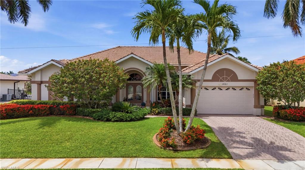 Enjoy coveted southern exposure and quick boating access to the Gulf from this meticulously maintained waterfront residence. Designed for both comfort and entertaining, the home features volume ceilings, tile flooring throughout the main living areas, elegant crown molding, a private den, and a formal dining area. The spacious kitchen offers custom cabinetry, granite countertops, and abundant storage.

The living area opens to the screened lanai, where the pool features a built-in table and bench—perfect for relaxing with your favorite beverage while enjoying the waterfront views.

Additional highlights include central vacuum, generator hookup, custom garage cabinetry, and a decorative display ledge beneath the crown molding in the guest bedroom, ideal for showcasing artwork or collectibles. Recent updates include a new air conditioning system with UV lights (2016) and PEX water lines installed in 2017.

Boating enthusiasts will appreciate the private dock equipped with a 14,000-pound boat lift and a 1,500-pound personal watercraft lift, providing quick access to the Gulf of Mexico. Built with durable metal stud framing and situated at an approximate 13-foot elevation, this home combines quality construction, thoughtful updates, and the exceptional waterfront lifestyle Marco Island is known for.
