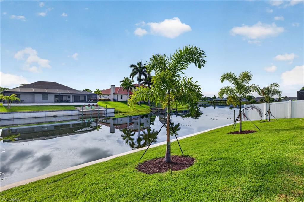 MOVE IN READY NOW NEW CONSTRUCTION! 24-FOOT SLIDING GLASS DOOR WITH STUNNING VIEWS OVER A WIDE FRESHWATER CANAL! Welcome to the Coral Haven Plan, where luxury design and waterfront living meet in perfect harmony. Designed exclusively for premier waterfront homesites, this expansive residence captures the essence of the Florida Sunlife lifestyle with a seamless indoor-outdoor connection that truly sets it apart. A dramatic 24-foot-wide sliding glass door opens to an enormous screened lanai featuring a heated pool and spa, offering the perfect balance of shaded relaxation and sun-drenched lounging while overlooking tranquil water views—ideal for entertaining or unwinding in true resort style. From the moment you arrive, exceptional attention to detail is evident, from the pristine paver driveway to the elegant finishes throughout. Inside, natural light pours across gleaming porcelain tile floors and up to soaring ceilings accented with detailed crown molding. The modern kitchen is a true showpiece, showcasing stainless steel appliances, all-wood soft-close cabinetry, quartz countertops, a large island with breakfast bar, and a spacious walk-in pantry—perfect for both everyday living and hosting in style. The thoughtfully designed split floor plan offers outstanding flexibility for multi-generational living, remote work, or growing families. Two luxurious primary suites each feature tray ceilings, walk-in closets, and full en-suite bathrooms, providing comfort and privacy for all. The location is ideal with close proximity to everything Cape Coral offers. With impact windows and a no flood zone location, this home offers peace of mind and extremely reasonable insurance costs. Blending sophistication, functionality, and an unbeatable waterfront setting, this residence delivers the ultimate Florida lifestyle. One or more photo(s) was virtually staged. This is the Coral Haven Plan.