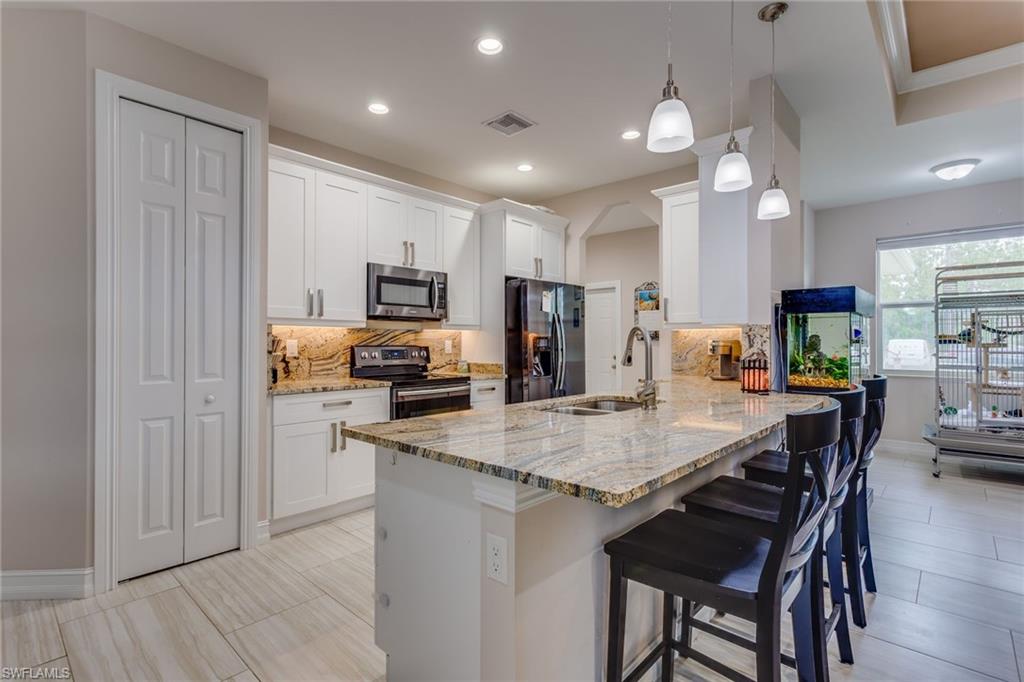 Come see this spacious open floor plan with 3 large bedrooms, 2 bathrooms, and a 2 car garage. Built in 2018 so it is like New Construction.  Too many upgrades to list; gorgeous white wood soft close cabinets throughout, granite countertops in kitchen and bathrooms, black stainless steel appliances in the kitchen, separate laundry room comes with washer & dryer, soft close white cabinets and laundry sink, crown molding, tray ceiling, modern tile on all floors, NO CARPET! Master bathroom has dual sinks and a separate tub and shower.  Sprinkler system, paved asphalt driveway, tiled (French travertine) enclosed lanai with summer kitchen. Plenty of room to build a pool.