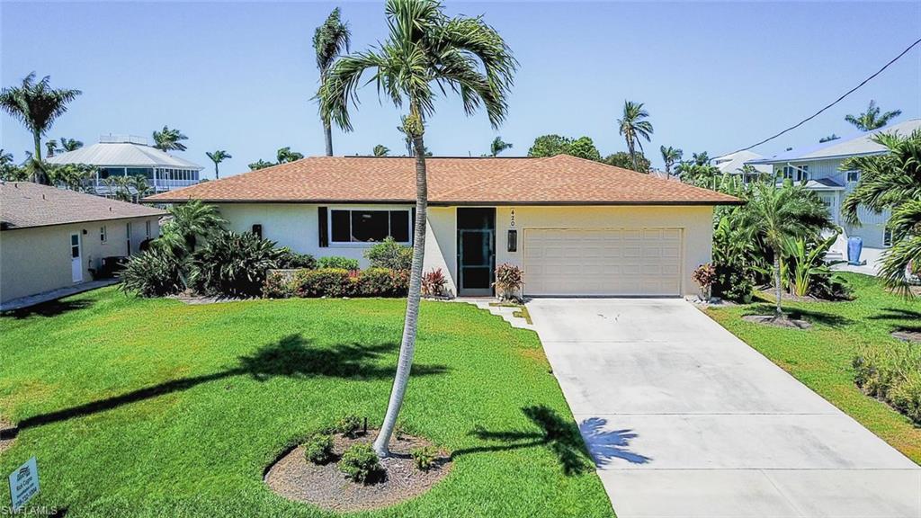 You've found your home in the sunshine at 420 San Juan! From the moment you pull into the driveway, you'll immediately notice this home is elevated, above FEMA flood elevation in fact! Outside, you'll notice a like-new roof, lush landscaping, screened lanai with irregular-shaped pool, nice dock with partial bay view and large backyard. The floor plan, once inside, is quite inviting! A large open room spans from the dining into the living area, with sliders leading to an elevated lanai overlooking the pool and backyard. The home features a split floor plan, along with a third bedroom which could also double as a den or utility area, off the garage. The master suite features its own bath and access to the lanai, and the second bathroom passes right out to the pool! Ready for your interior updates and touches, you'll be sure to see the potential this home holds to be a seasonal or full-time residence. San Juan Avenue is the first street on Capri, so you are quick to Capri's dining options or to shopping on Marco Island and Naples. Boaters will delight in the quick, direct Gulf access. Call today to see this unique opportunity to live and love life, on Isles of Capri!