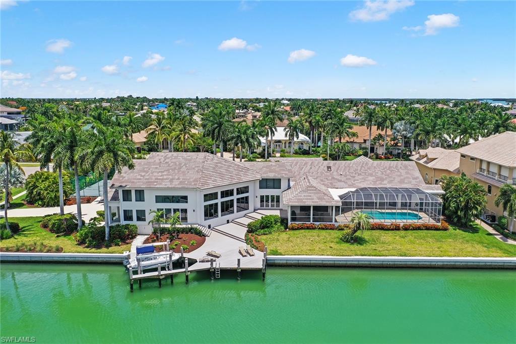 Stunning home located in the estate area of Marco Island offers island living at its finest. This rare, seven-bedroom, nine-bath home on two lots features direct access to Roberts Bay. Extensive renovations in 2019-2020 include new seawall, impact-resistant windows, doors, roof, lighting and landscaping. This home makes entertaining family and friends easy with a living room, family room, billiards, bar area, flat-screen TV, dining room that can accommodate 20 guests with two large tables and a round table that can accommodate six. The kitchen can seat eight and boasts an electric cooktop, wall oven and stainless steel appliances. The large master suite features a sitting area, two walk-in closets, French doors leading to the lanai and an en-suite bath with dual sinks, shower and a separate tub. Each guest bedroom offers private baths with walk-in showers perfect for privacy. This beautiful home features a large, covered lanai area that overlooks the gorgeous pool and spa. For the tennis or basketball player, there is a tennis/basketball court on the property. The back of the home with western exposure has a dock and lift with direct water access to Roberts Bay.