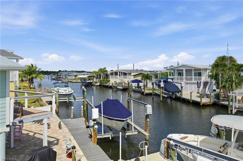 One or more photo(s) has been virtually staged, AI generated or rendered.  BOATER’S DREAM! NO HOA FEES, NO RENTAL RESTRICTIONS & WEEKLY RENTALS ALLOWED. Just over the bridge from Fort Myers Beach, this elevated canal-front home on San Carlos Island offers direct Gulf access with open water reached in less than 2 minutes. Designed for those who love life on the water, this property features a private dock with water and electric service, a 10,000 lb boat lift, remote-controlled jet ski lift, and floating kayak dock.
The main living level features a bright, open floor plan with plantation shutters and direct access to a spacious deck overlooking the canal and dock. The kitchen is appointed with solid wood soft-close cabinetry, granite countertops, stainless steel appliances, and a center island for food prep and seating. The primary suite offers an updated bath with quartz countertops and a large walk-in shower, while the second upstairs bedroom includes its own full bath a nd ample closet space.The lower level (approximately 800 sq ft) provides exceptional flexibility with a garage, sunroom, half bath with shower, and a BONUS room ideal for guests, a home office, fitness space, or studio. Additional features include a paver driveway and garage with retractable screen for added comfort and convenience. Conveniently located minutes from Fort Myers Beach, Margaritaville Resort, waterfront dining, and island entertainment, this rare waterfront opportunity offers the perfect blend of boating access, flexible living space, and investment potential. Whether you’re looking for a full-time residence, vacation getaway, or income-producing property, you’ll appreciate the weekly rental potential, no HOA fees, and direct access to open water in under two minutes.