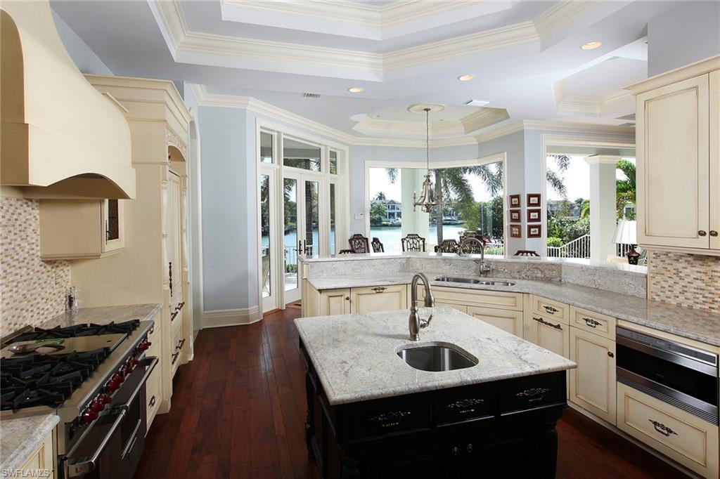 Perched on the bay in the desirable Moorings neighborhood, this West Indies-style home is the ultimate coastal retreat. The open floor plan reveals stunning water views from nearly every room. The exquisite interior is infused with hardwood floors, crown molding and a gas fireplace. A chef’s dream, the gourmet kitchen has been designed with a six-burner gas range, large center island with additional prep sink, light granite countertops and custom tile backsplash. With French doors opening to the bayfront patio, the master suite boasts a sumptuous bath with chiseled travertine marble, dual granite vanities, a large double shower and separate soaking tub. The outdoor oasis is replete with a pool, spa and outdoor kitchen overlooking the bay. Lush landscaping and custom pavers frame this elegant home, just minutes from the sophisticated shopping, dining and culture of downtown Naples.
