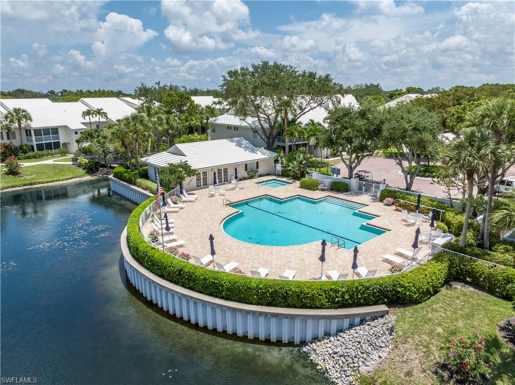 Beautifully landscaped surroundings welcome you to this exceptionally peaceful and private garden view residence.  The desirable end-unit ground floor location provides great convenience with easy access to the assigned covered parking. This charming residence features a split floor plan with spacious living area and bedroom suites, generous closets, and a versatile glass and screen enclosed lanai that provides year round enjoyment. Residents of Willow Brook at Pelican Bay enjoy a beautiful lakefront community pool, spa, and social room where friendly neighbors gather. LOWEST PRICE per square foot in Pelican Bay, this lovely residence offers an outstanding entry-level opportunity for exceptional living in Pelican Bay.  This exceptional community offers miles of spectacular beaches, private dining, fitness center, wellness studio, kayaking, tennis, and numerous walking paths.