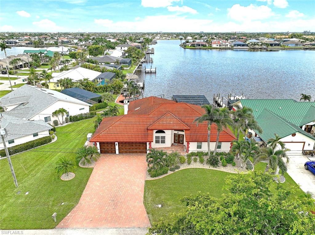 Looking for your million dollar view & gulf access home?  Experience waterfront luxury living in this highly-desired SW Cape Coral tropical oasis home priced to Sell. Home did NOT flood during Ian & is located on the highly-desired 8 Lakes where you can enjoy your morning coffee with the sunrise on a huge lanai thru the picturesque window screens. Lanai boasts a resort style heated infinity pool/spa, outdoor kitchen & lakeside seating where you can comfortably fish or just enjoy the peaceful views.  With 3,027 sqft, & oversized lot, you will enjoy the split floorplan with 4 large bedrooms (or 3+Den) & 3 full baths, with a 3 ½ car garage (mancave), & is sold TURNKEY!  This unique home is an entertainer’s dream & is loaded with upgrades from intricate tray & vaulted ceilings, custom lighting, shelving, impact windows, pocket sliders, 5 sets of glass sliders w/lakeviews, electric storm shutters, full wall of den built-ins, a fab butler’s pantry w/massive storage, custom lighting, eat-in kitchen & skylights  to a wood-burning fireplace & bar.  Additional upgrades include an energy efficient metal roof, 2 A/C units,&  boat dock with captains walk, & 10,000# boat lift w/electric & water.