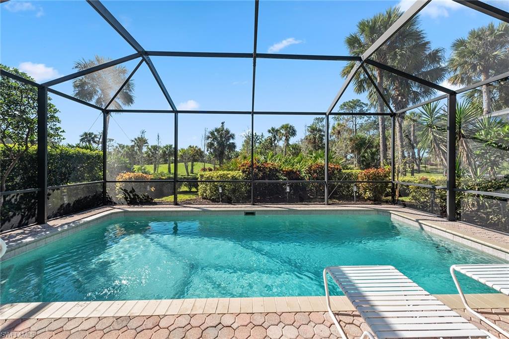 An exceptional former model home with southwestern views, on the single-loaded end of the street on the 12th hole of the Rookery Golf Course, is ideal for taking in stunning sunsets from your private lanai. Boasting 1,967 square feet of thoughtfully designed living space, this residence offers negotiable furnishings, three bedrooms, two baths and a two-car garage. The exterior impresses with a 2019 tile roof, a paver driveway and walkway and lush landscaping, all within distance to the clubhouse in the award-winning community of Fiddler’s Creek. Inside, soaring 10-foot ceilings, crown molding and recessed lighting create a bright and welcoming ambiance, while arched windows and upgraded fixtures add timeless elegance. The open kitchen features KitchenAid® stainless steel appliances, white cabinetry, under-cabinet lighting, granite countertops, a glass tile backsplash, a two-seater breakfast bar and a large pantry, making it functional and stylish. The adjoining dining area and light-filled family room create a space for entertaining or everyday living. The owner’s suite is a serene retreat, showcasing wood flooring, a vaulted ceiling and a bank of windows inviting natural light. Dual walk-in closets and a luxurious en-suite bath with a deep soaker tub, dual vanities and a frameless glass-enclosed walk-in shower complete this private oasis. Two additional bedrooms also feature wood flooring, with one offering its en-suite bath. The outdoor living area is equally impressive, with a covered lanai featuring brick pavers, ample room for lounging and a sparkling pool with privacy hedges and a screen enclosure. A no-see-um automatic mister system ensures comfort year-round, while one of the home’s five mounted TVs is conveniently in the lanai for outdoor entertainment. Recent updates include a new washer and dryer and a new pool heater, and the home is prewired for a generator for added convenience and peace of mind. Additional upgrades include California Closets throughout the home, a garage door under warranty and five total TVs for easy move-in comfort. Residents of Fiddler's Creek enjoy world-class amenities, including championship golf, a fitness center, tennis, pickleball, bocce, a full-service spa, a sauna, casual and fine dining and a resort-style pool. Golf, beach and marina memberships are available, offering even more ways to enjoy the Florida lifestyle. Ideally between downtown Naples and the pristine beaches of Marco Island, this home is a combination of luxury, privacy and convenience. Plus, the CDD is fully paid. Don’t miss this rare opportunity to own a beautifully appointed home in one of Naples'sought-after communities.