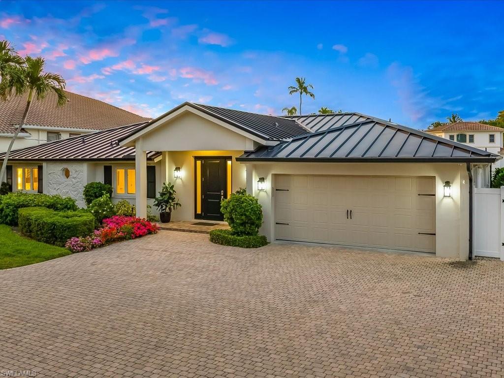 In the coveted “Nifty Fifty” enclave of The Moorings—an intimate stretch of just fifty waterfront homesites where ownership is often held for generations—this fully reimagined coastal residence captures the essence of Naples yachting life with direct, no-bridge Gulf access through Doctors Pass. From the moment you enter, wide-plank wood flooring introduces a sense of understated refinement, guiding you into interiors designed for both relaxed living and effortless entertaining. The kitchen serves as the home’s centerpiece, thoughtfully appointed with quartz surfaces, a gas cooktop beneath a custom-crafted hood, wall oven, microwave, wine refrigeration, and dual sinks. Generous island and bar seating create a natural gathering space, flowing seamlessly into the family room where an expansive picture window frames tranquil canal views and passing vessels en route to open water. A formal dining room set behind French doors offers an elegant setting enhanced by natural light and coastal breezes, while a separate living room provides a more intimate retreat. Privately positioned, the primary suite opens directly to the pool terrace and features a fully renovated bath with a spacious walk-in shower and dual-sink vanity. Custom closet systems throughout the home reflect a commitment to both design and organization. Outdoors, a refinished pool overlooks shimmering waterways, complemented by a private dock and a new twenty-thousand-pound lift—tailored for effortless boating access. Recent enhancements, including a new roof, HVAC system, water heater, seawall and dock, as well as a climate-controlled garage with epoxy flooring, ensure a truly turnkey experience. Positioned just moments from the Gulf and minutes to the refined dining and shopping of 5th Avenue South, 337 Mooring Line Drive represents a rare opportunity to secure a waterfront lifestyle defined by access, exclusivity, and enduring coastal elegance.