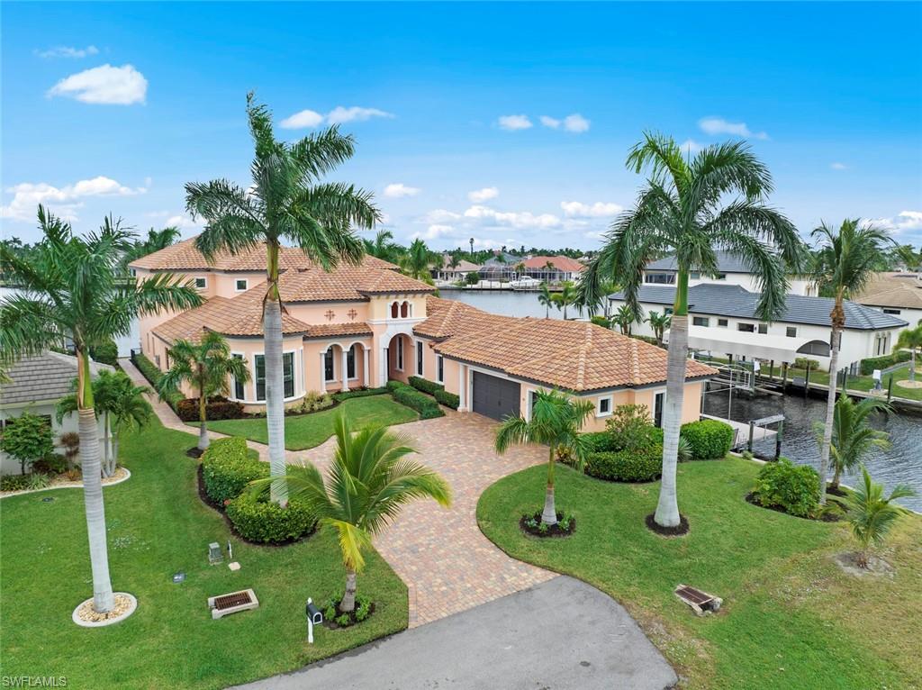 This custom-built waterfront FURNISHED home is designed with timeless luxury and exceptional craftmanship.  Corner lot is situated at the widest point of the "Y" intersection of the San Carlos & Bimini Bay Canals. Beautifully designed and decorated from top to bottom. 1st floor: a 2-bedroom primary suite, 2 more BR's, a formal living room, office/den, dining room, chef's kitchen w/ walk-in pantry, eat-in area & the family room. The upstairs is an exceptional true treat with last, but not least, the 5th BR, full bathroom, the incredible "game room," includes a wet bar, beverage fridge, built-in ice maker & poker table. What's left...a pool table, of course! Zero corner sliders on both 1st & 2nd levels that offer a seamless transition to indoor/outdoor living. Open the sliders to a large, covered balcony that REALLY shows the breathtaking water views.  Additional feature sheet providing the incredible upgrades this home has is available. This is by far a luxurious primary retreat or a lucrative vacation rental opportunity as this meticulous home offers the very best of everything!