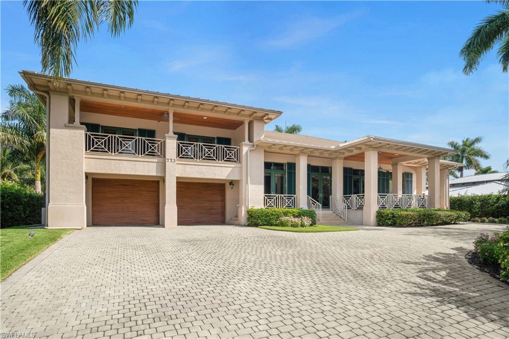 This prestigious Aqualane Shores waterfront, 4 bedroom, 3 bathroom plus den home is only 5 lots away from Naples Bay. The dock possesses a coveted, 27,000 lb capacity covered boat lift and a jet ski lift. The interior features an airy, open floor plan with high ceilings. Water views emanate throughout. In excellent condition with an updated kitchen and bathrooms, the home is equipped with quality appliances and a lovely fireplace. The spacious four car garage is attached to the elevated property. Walk to Gulf beaches and historic 3rd street restaurants and shoppes. An impressive, tree lined 18th street address greets you prior to arrival.