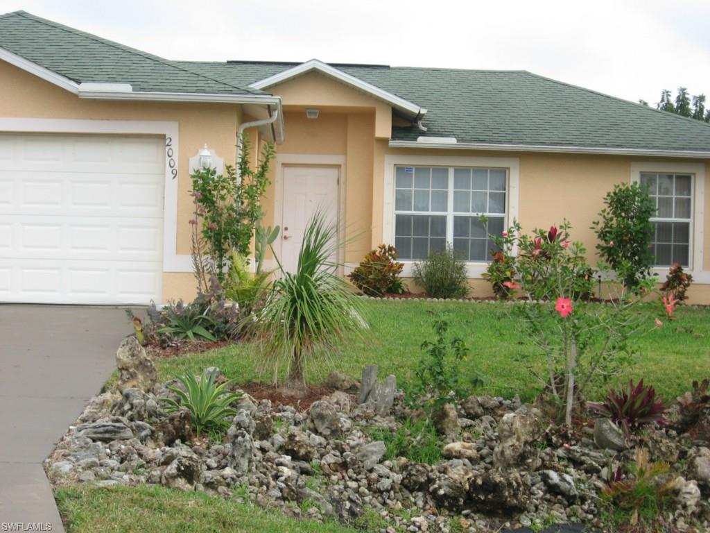 TROPICAL SETTING SURROUNDING THIS CHARMING CORNER LOT WITH 3/2/2 HOUSE WITH SCREENED PATIO.  ALL TILED FLOORS WITH WIDE BASEBOARD AND CROWN MOLDING.  BEAUTIFUL PLANTINGS WITH AUTOMATIC SPRINKLERS IN PLACE.  EXTRA CABINETS IN GARAGE; HURRICANE SHUTTERS IN GARAGE; W/D AND LAUNDRY TUB IN RESIDENCE.  ROOM FOR POOL.  CITRUS TREES, PALMS, MANGO, AVOCADOS, BANANAS AND PAPAYA AND MORE.